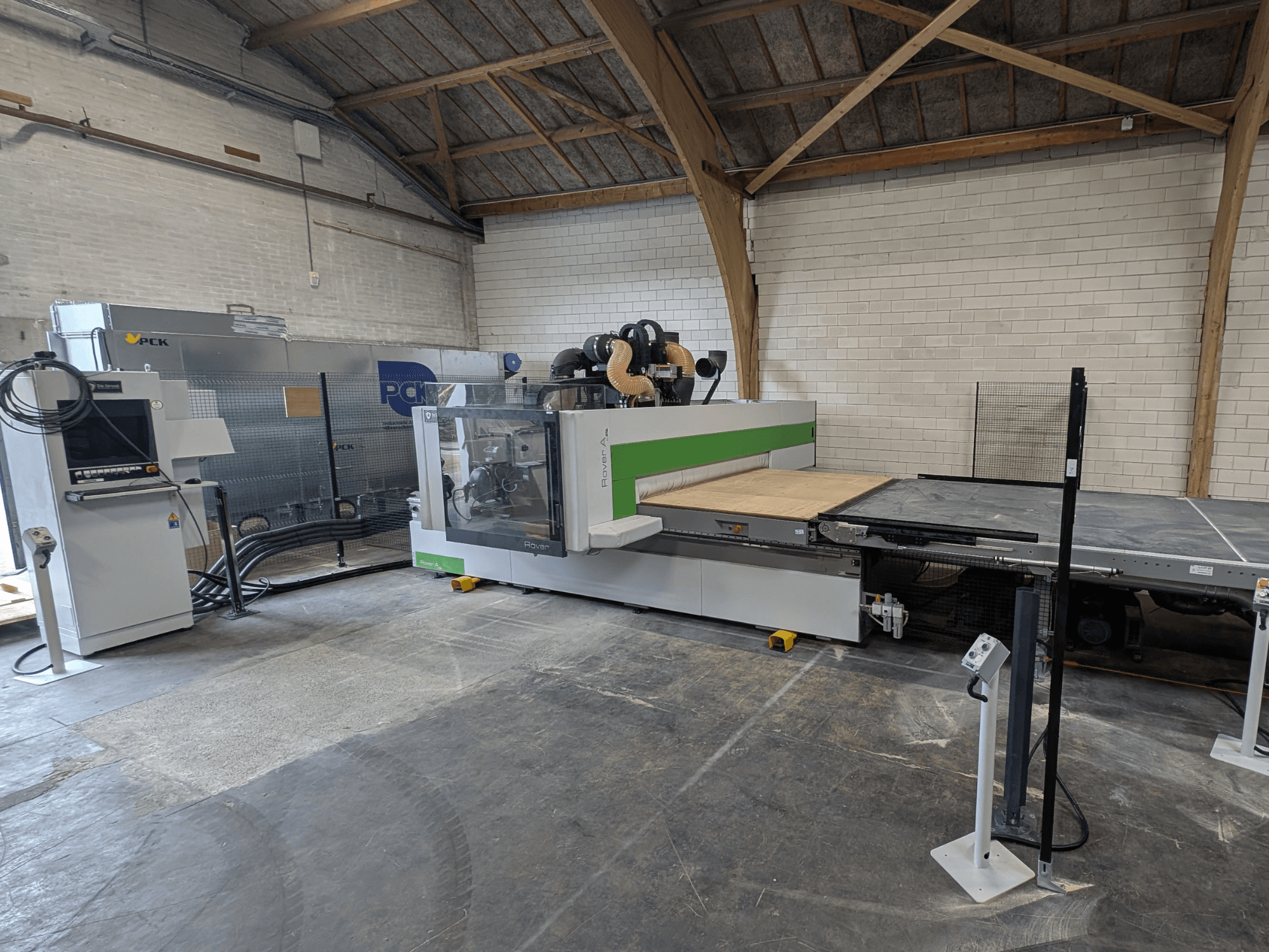 PCK CNC-Bearbeitungszentrum, Vorderansicht, mit großem Schneidbett, Bedienfeld, Staubabsaugung und robuster Konstruktion.