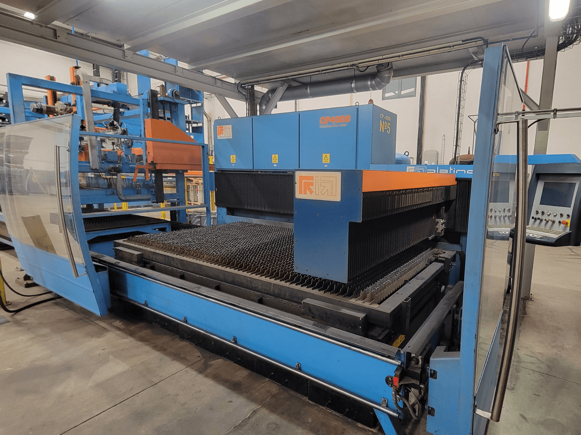 RIK CP4060 Laserschneidmaschine in Blau, Seitenansicht mit Metallschneidegitter und Bedienfeld. Ideal für industrielle Anwendungen.