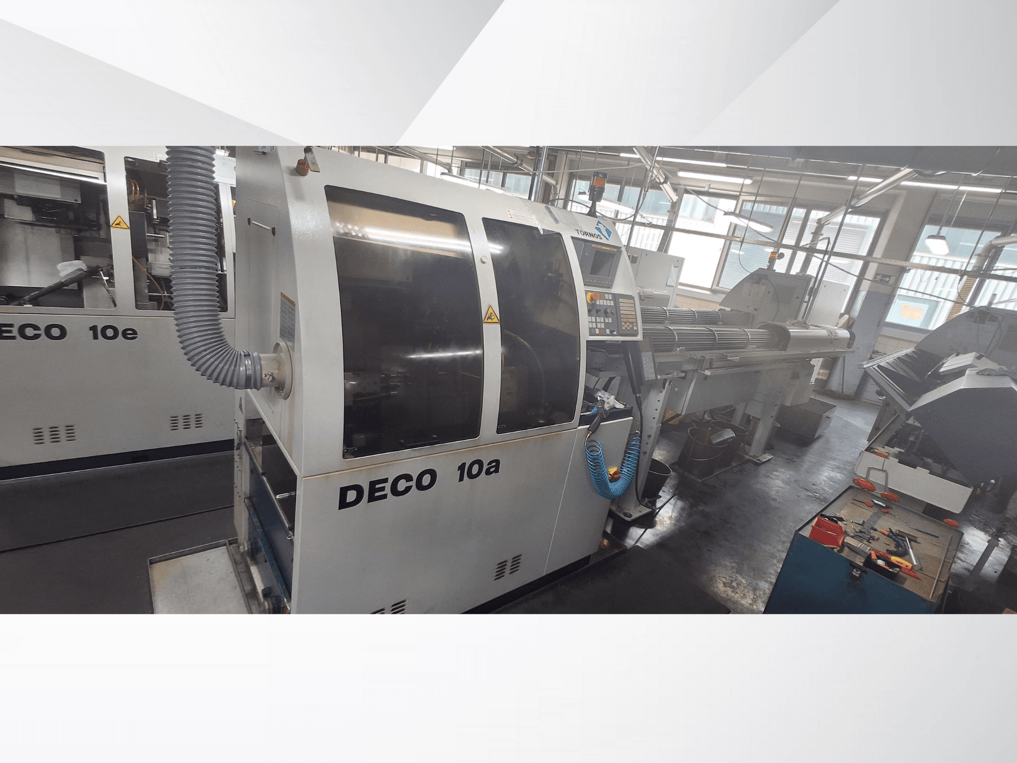 DECO 10a CNC-Maschine in einer Werkstatt, mit Frontansicht, Bedienfeld und Absauganlage. Robuste Bauweise und Präzisionswerkzeuge.