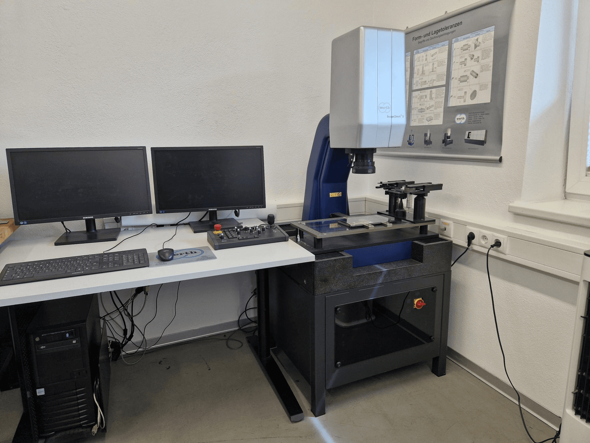 Werth Scopecheck 300S CMM in einem Laboraufbau; umfasst einen Messtisch, zwei Monitore und ein Bedienfeld.