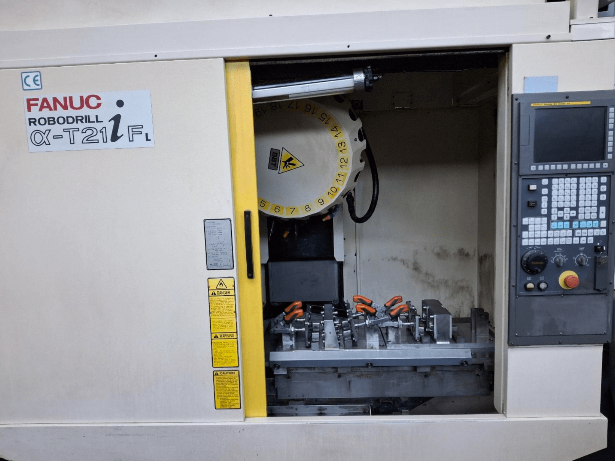 FANUC ROBODRILL α-T21iFL Vertikal-Bearbeitungszentrum, Frontansicht mit Werkzeugen und Bedienelementen im Inneren des Maschinengehäuses.