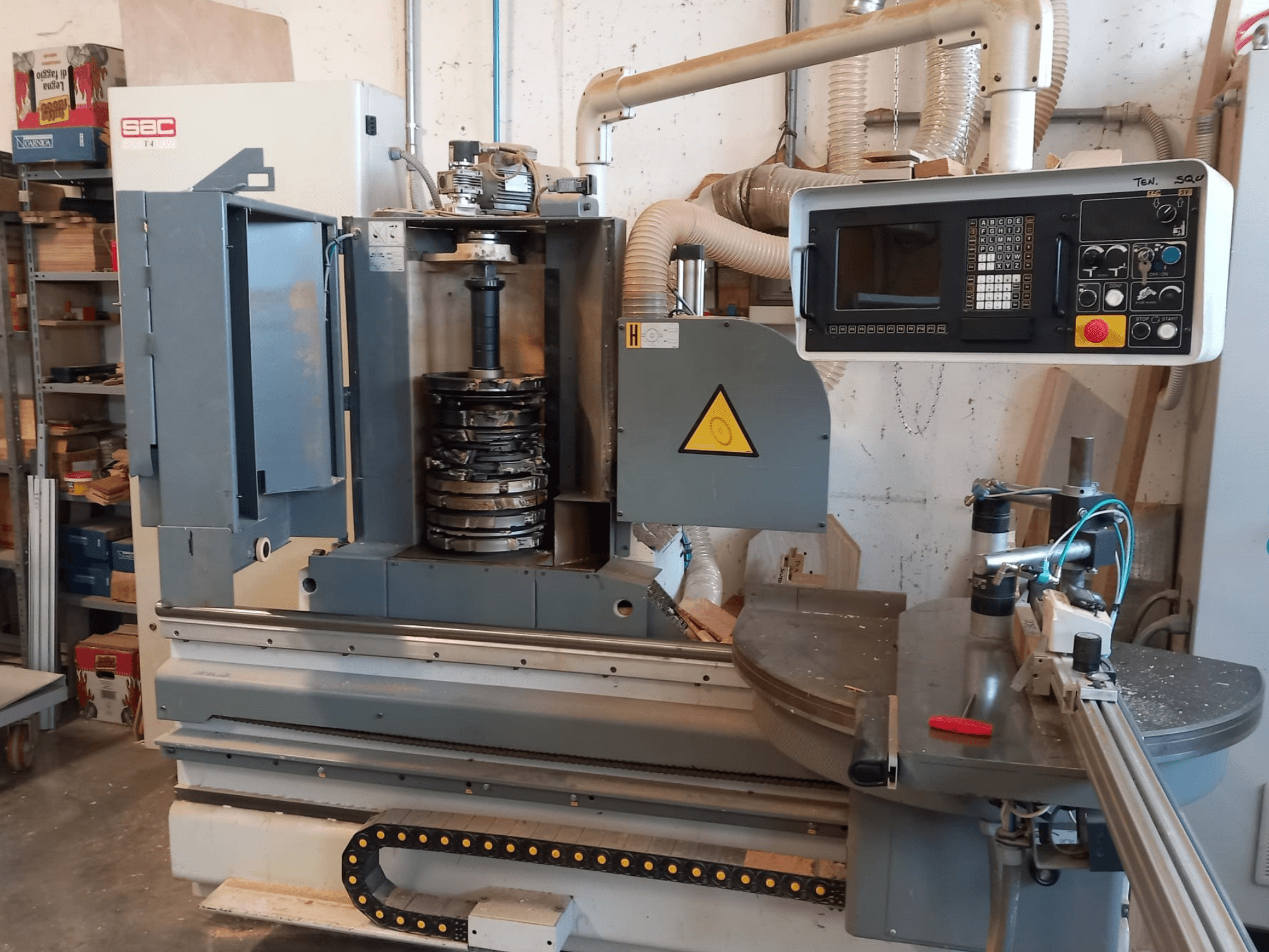 Vorderansicht der SAC T4TL-Holzbearbeitungsmaschine mit sichtbarem Bedienfeld, rotierendem Werkzeughalter und Staubabsaugsystem.