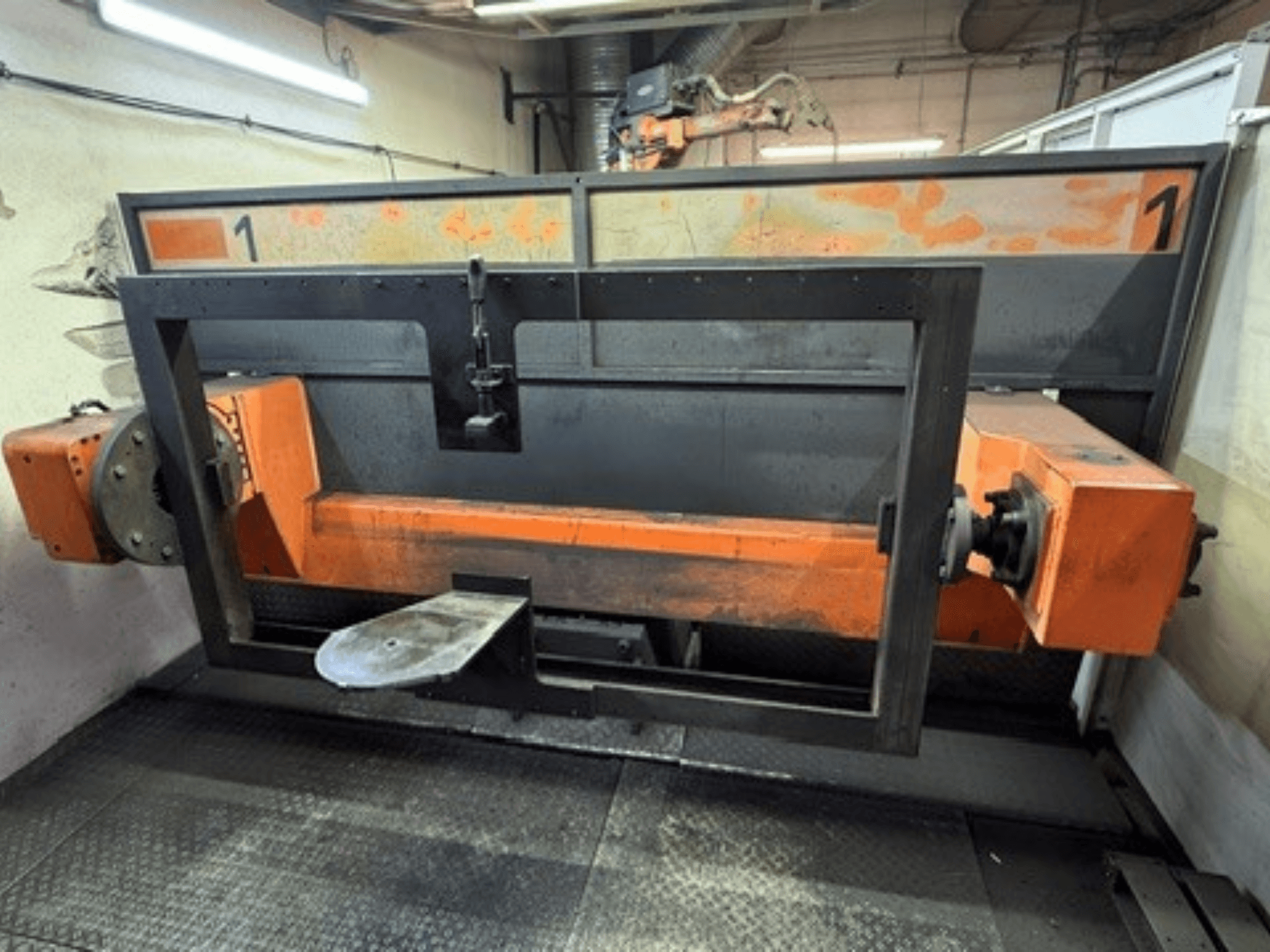 Vorderansicht der ABB IRB 2400L-Schweißzelle, die einen großen Roboterrahmen mit orangefarbenen und schwarzen Bauteilen in einer Werkstattumgebung zeigt.