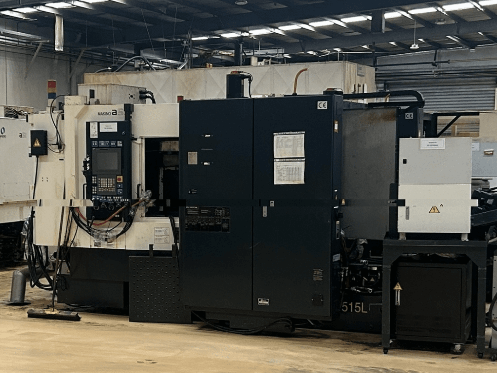 Horizontales Bearbeitungszentrum Makino A51-5XR, Vorderansicht mit Bedienfeld, Netzteil und Maschinenkomponenten.