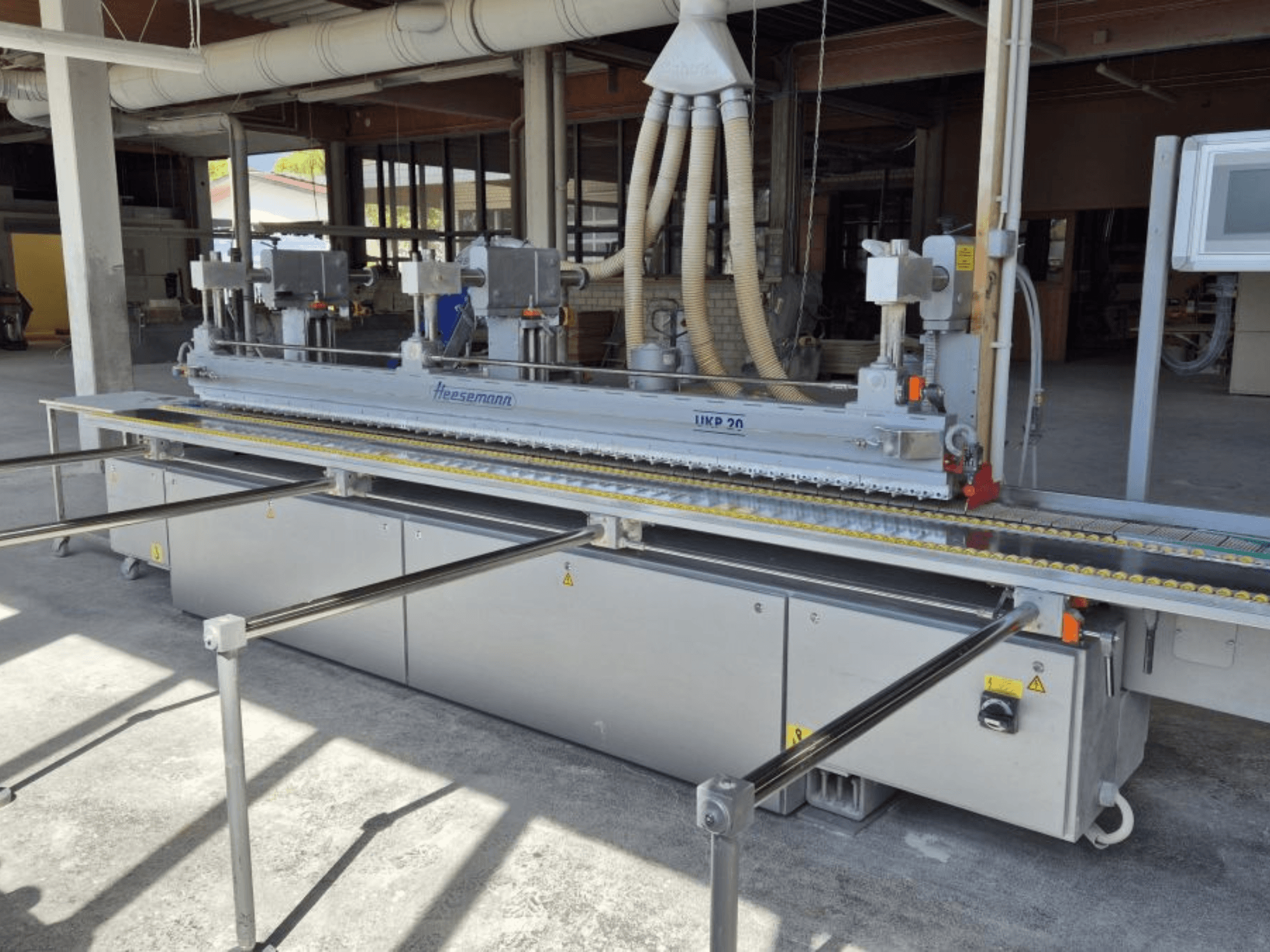 HEESEMANN UKP 20 Bandschleifmaschine in der Vorderansicht, mit Doppelmotoren, verstellbarem Transportband und Schutzabdeckungen.