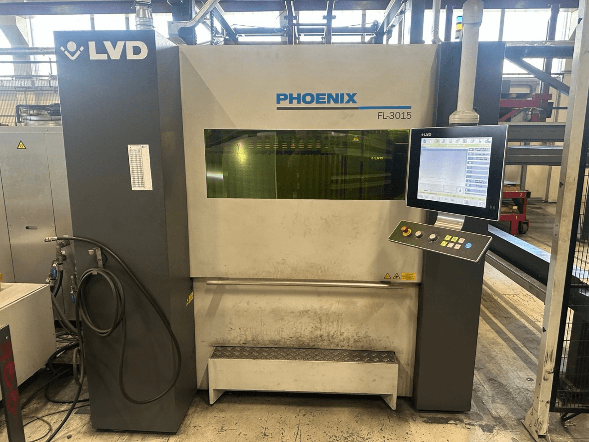 LVD Phoenix FL-3015 Laserschneidmaschine, Vorderansicht, mit digitalem Bedienfeld und sichtbaren Schläuchen.