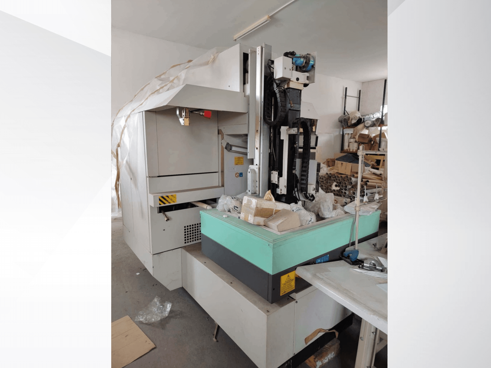 AGIE AGIETRON INTEGRAL 2 Senkerodiermaschine in der Seitenansicht, mit grünem Arbeitstisch und verschiedenen Werkzeugen.