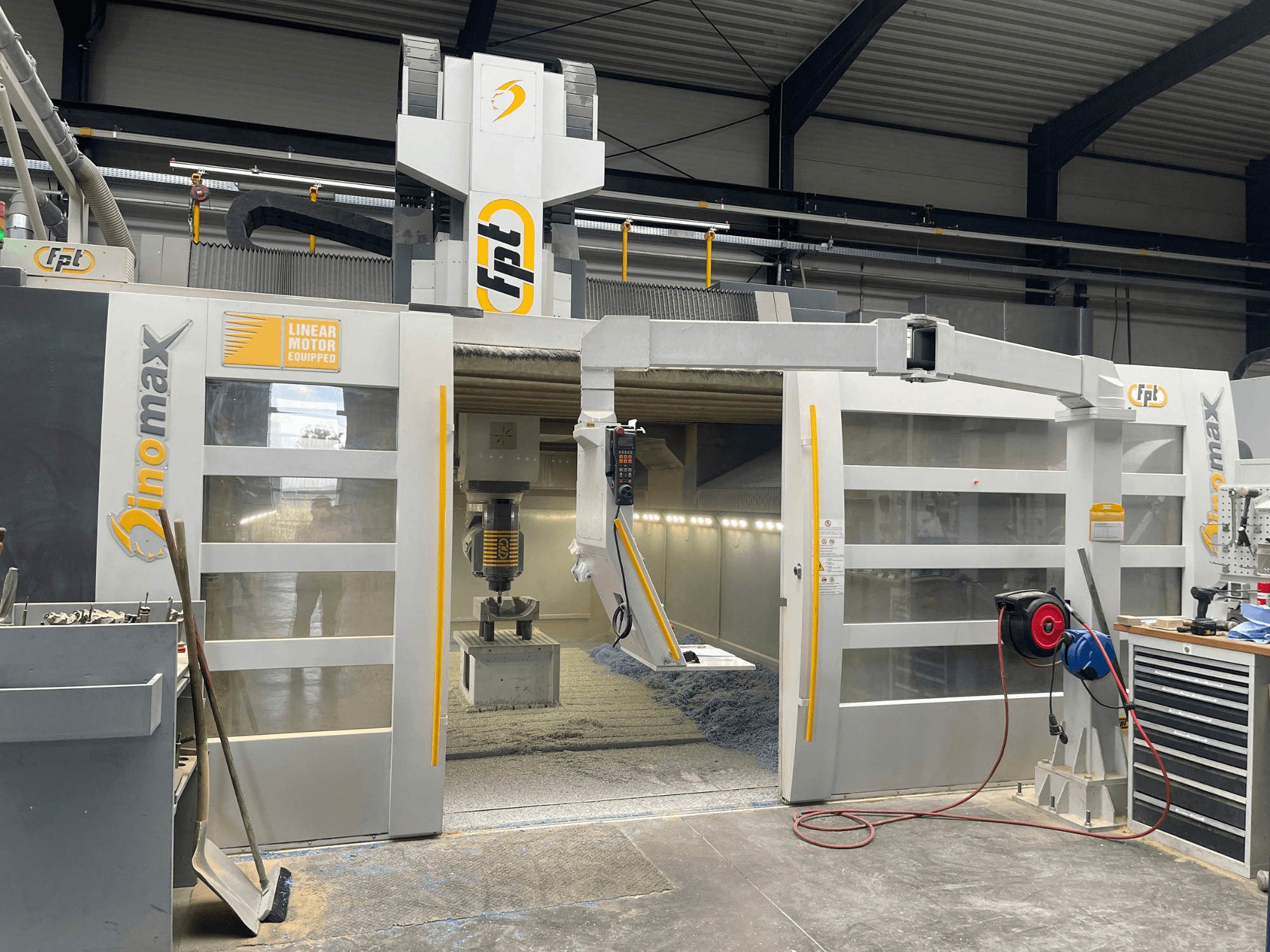 Die Portalfräsmaschine FPT DINOMAX von vorne gesehen, mit Details zum Linearmotor, zum Arbeitsbereich und zum Bedienfeld.
