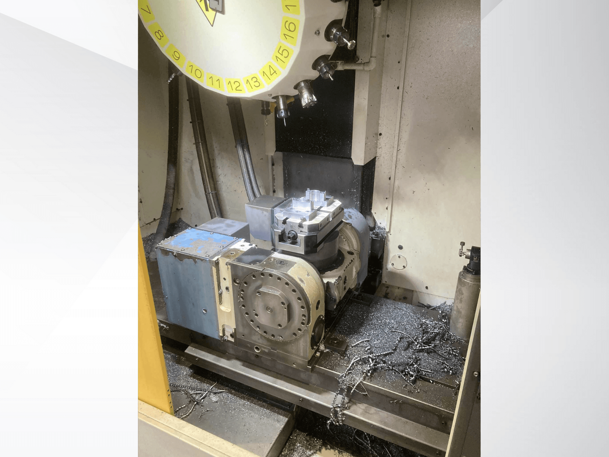 CNC-Fräsmaschine in Betrieb, Vorderansicht. Inklusive rotierender Spindel und Metallspänen auf der Werkbank.
