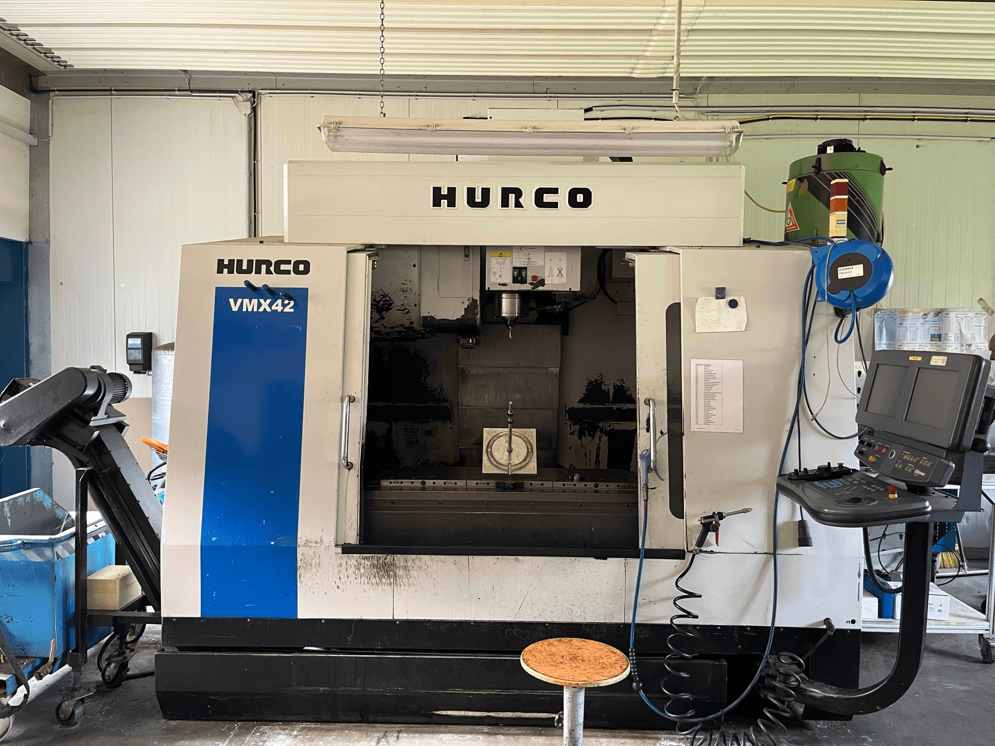Hurco VMX 42 Vertikal-Bearbeitungszentrum in der Seitenansicht, mit Bedienfeld, Spindel und Werkstückeinrichtung.