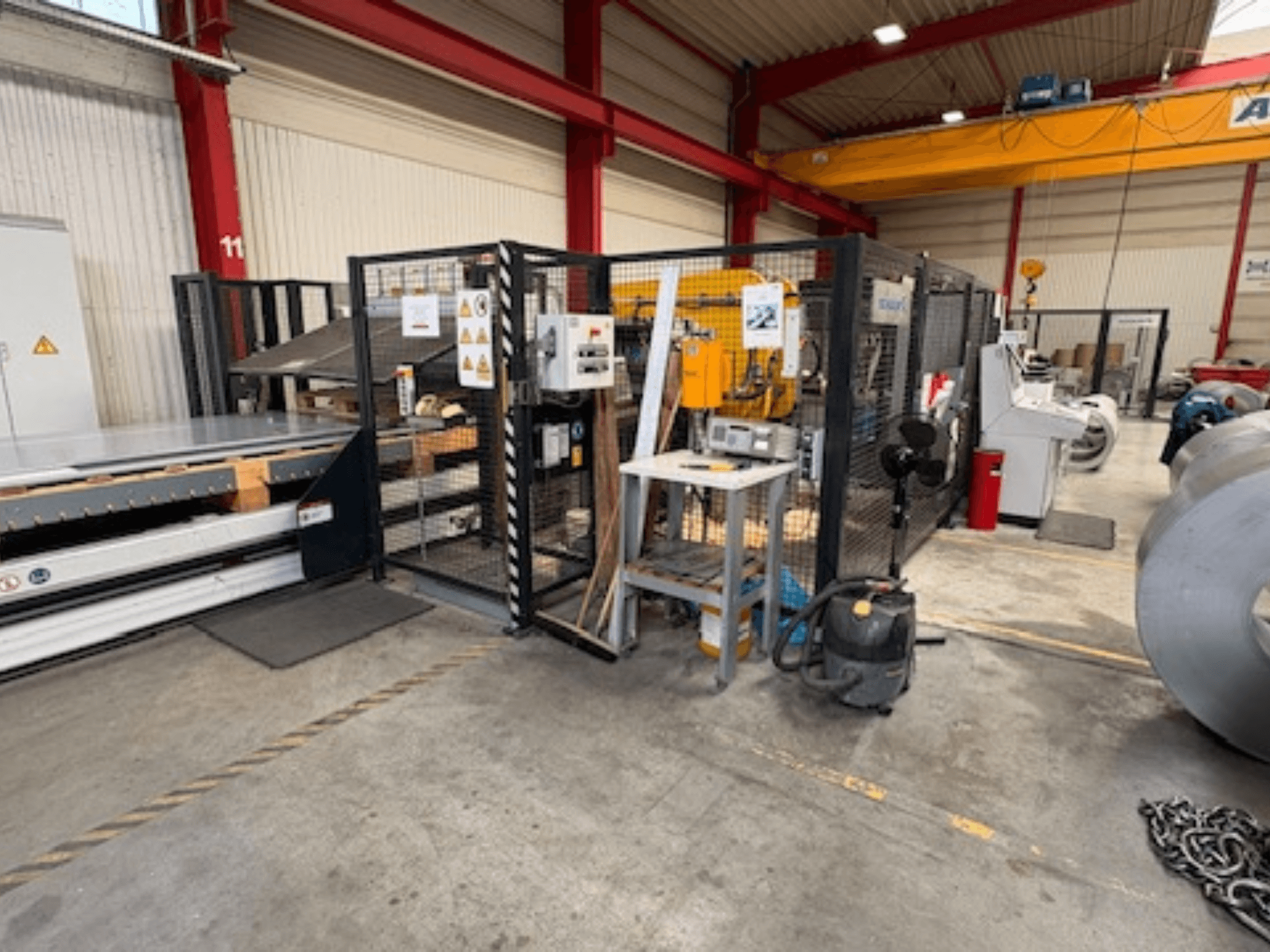 Blechbearbeitungsmaschine von SCHULER, Modell AC-PLS-1600-M, in einer Werkstatt, Seitenansicht mit Sicherheitsabtrennung und angrenzenden Anlagen.