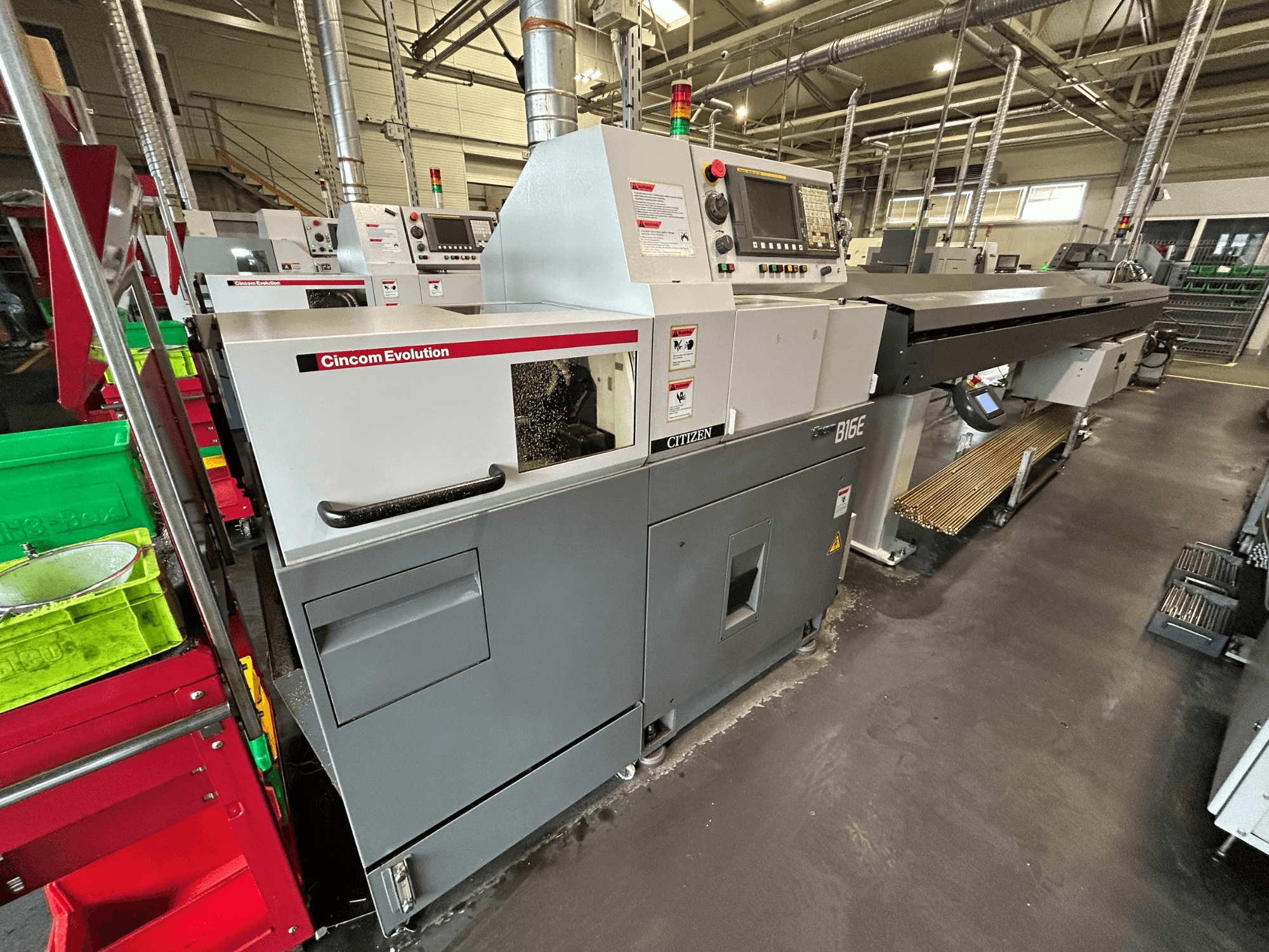 Die horizontale Drehmaschine „Citizen B16“ in Seitenansicht, mit Bedienfeld, Arbeitsbereich und den daneben befindlichen Materialbehältern.