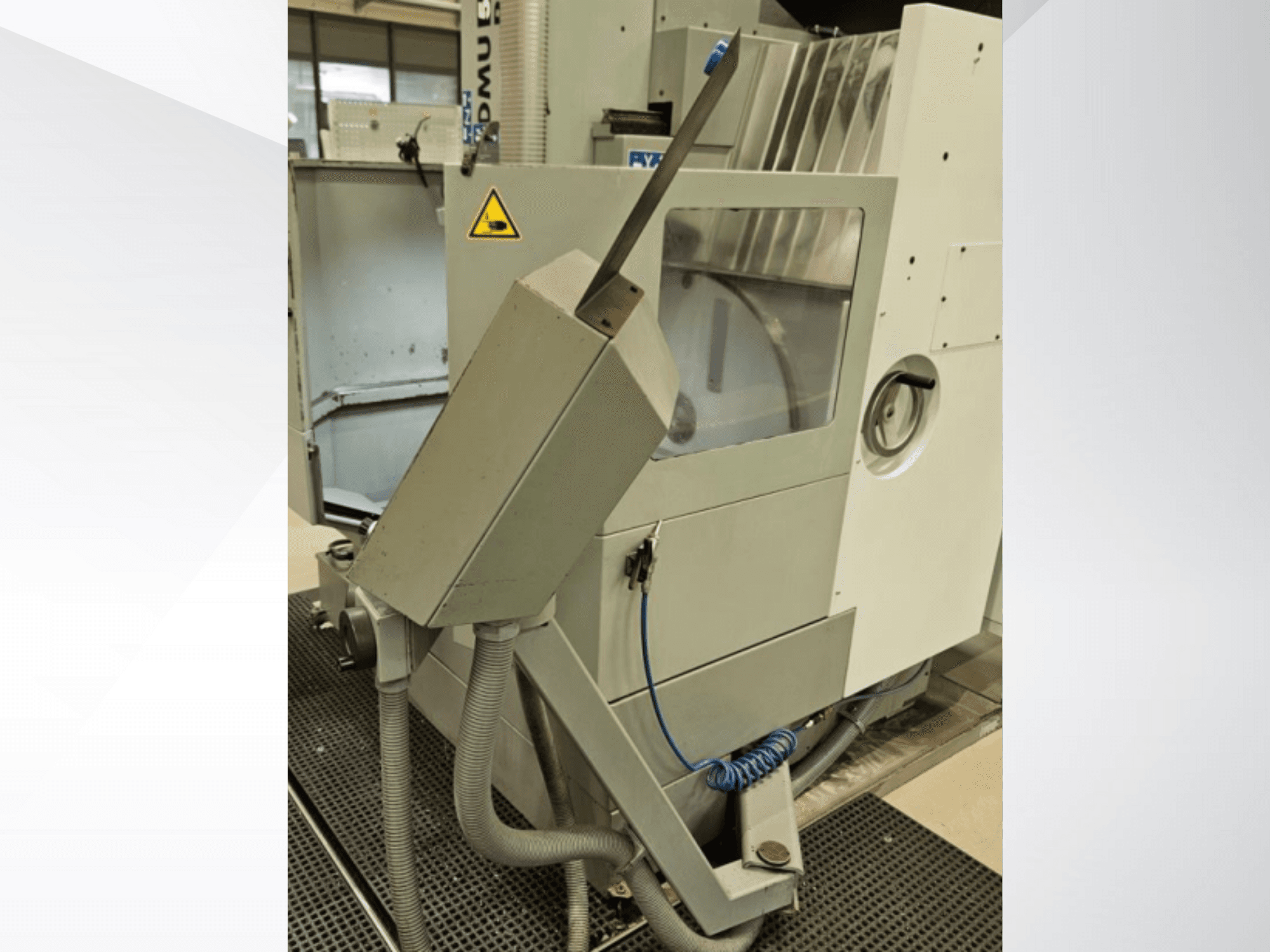 Seitenansicht der DMU-Fräsmaschine mit Kühlmitteldüse und integriertem Bedienfeld; mit Sicherheitswarnschild.