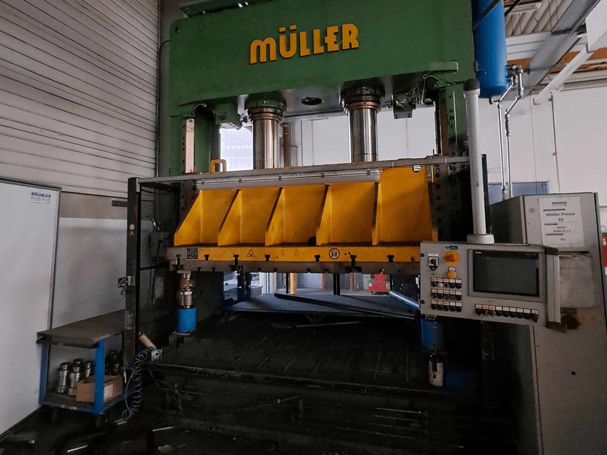 Vorderansicht einer Metallpresse vom Typ Müller SE 300-25.1.1 mit gelben Presskomponenten und einem Bedienfeld an der Seite.