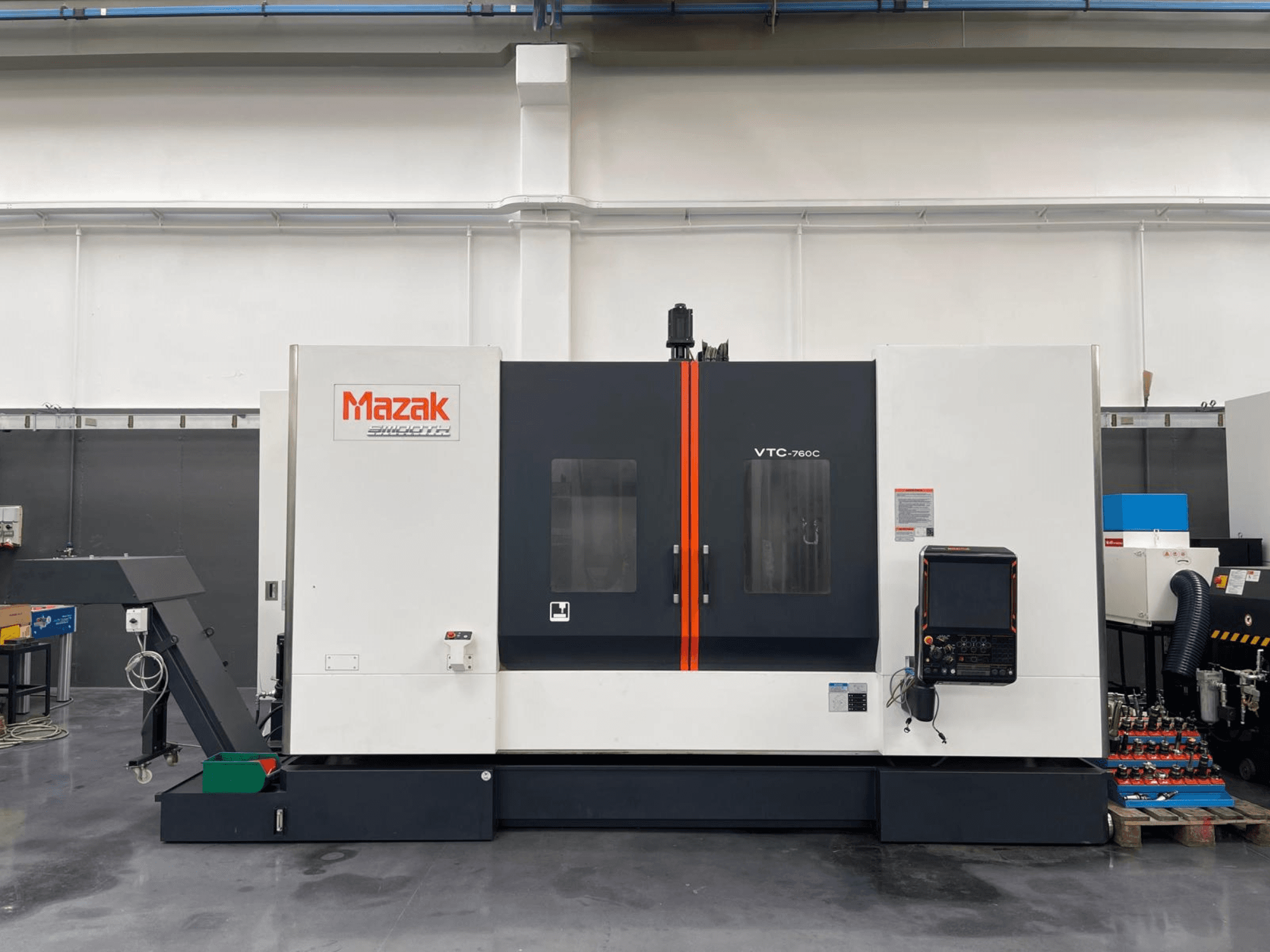 Mazak VTC 760C Vertikal-Bearbeitungszentrum, Seitenansicht mit Bedienelementen, weiß-schwarzem Äußeren und orangefarbenen Akzenten.