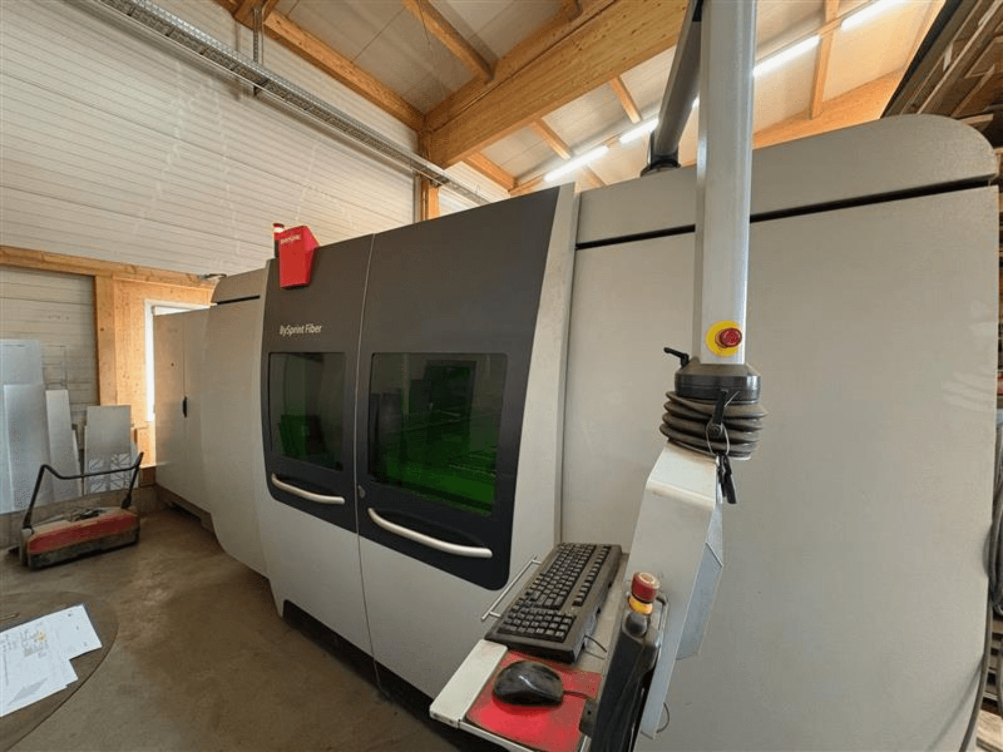 Bystronic ByJet Fiber Schneidmaschine in einer Werkstatt, Frontansicht mit Bedienfeld und zwei grünen Sichtfenstern.