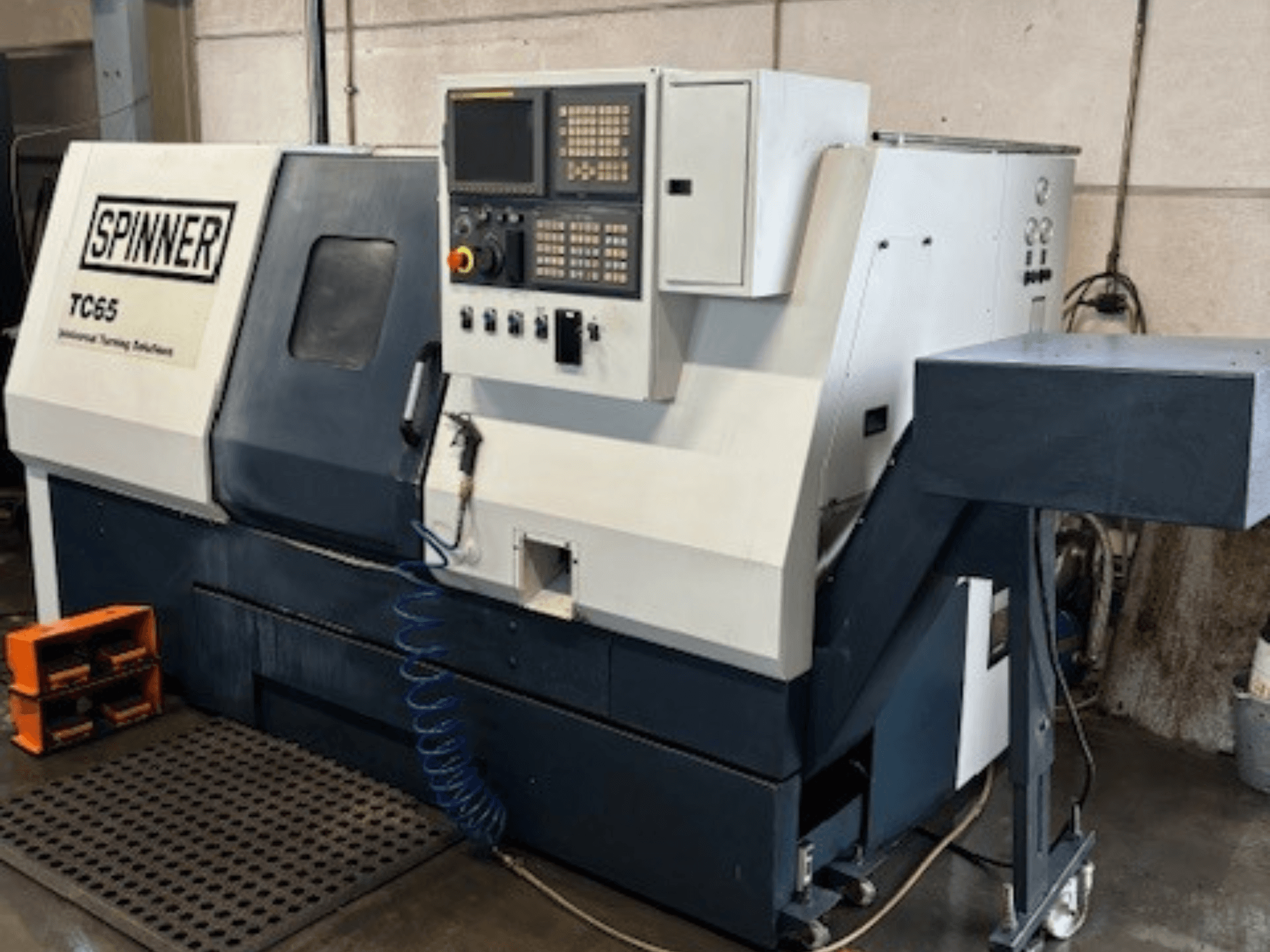Industrie-Drehmaschine Spinner TC65, Vorderansicht, mit Bedienfeld, Druckluftleitung und Werkzeugablagefläche.
