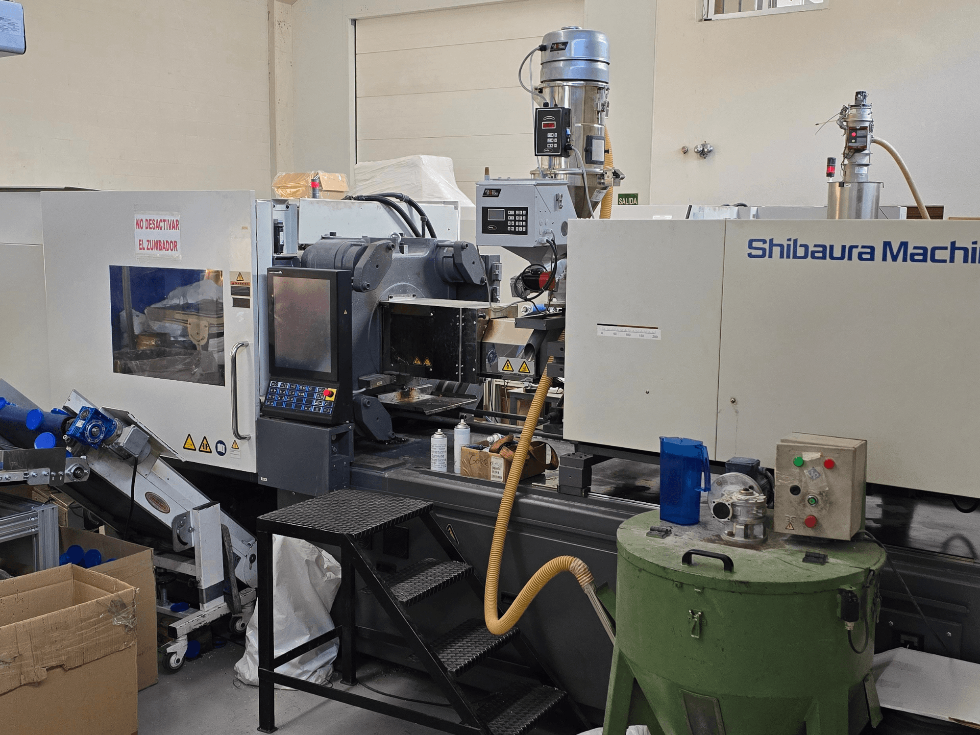 Frontansicht der elektrischen Spritzgießmaschine SHIBAURA EC230SXIII-8A mit Bedienfeld und angrenzenden Geräten.