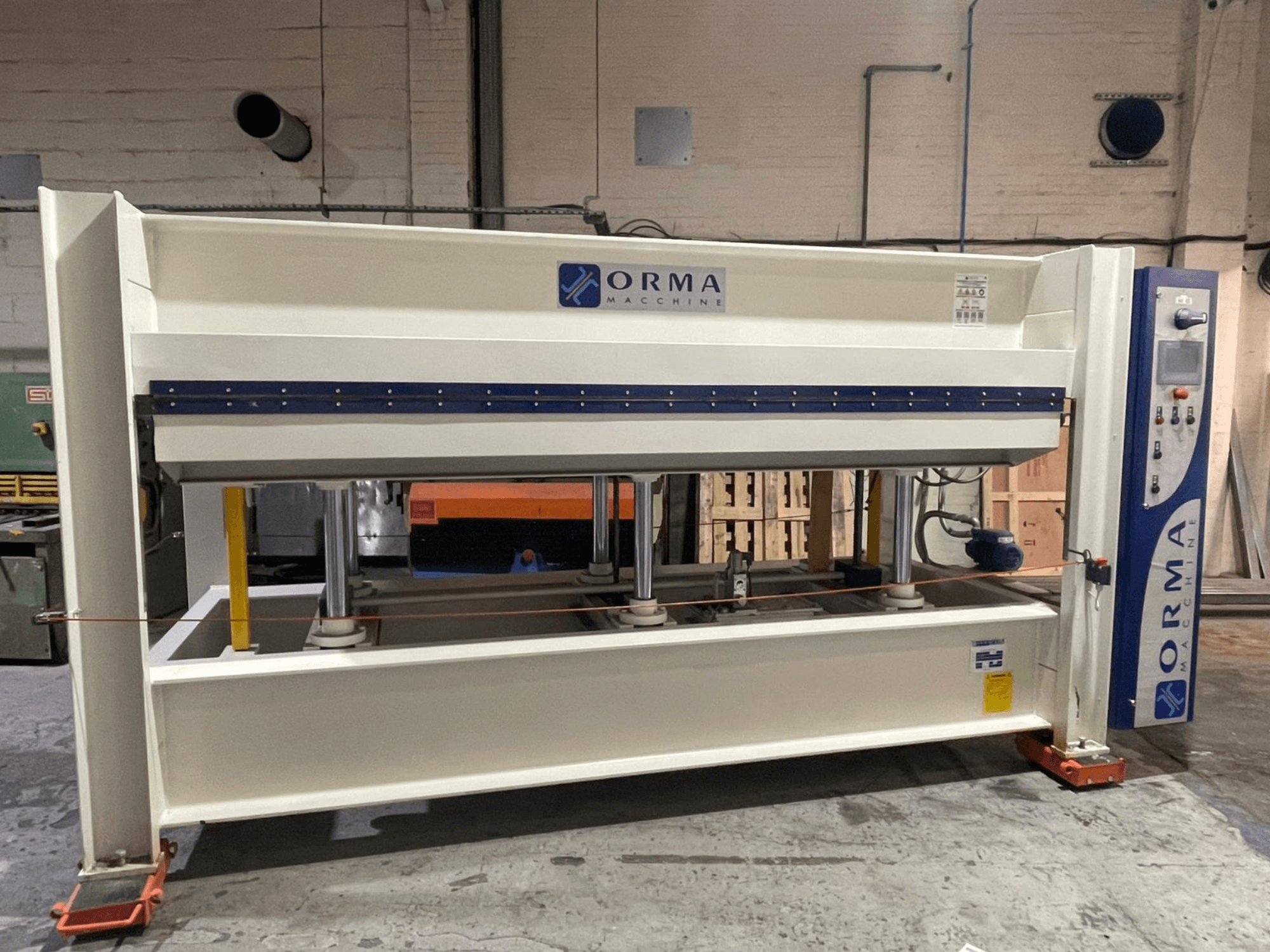 Hydraulische Presse der ORMA-Maschinen, Vorderansicht, mit silberner Oberfläche, Bedienpult rechts und aufrechten Presskolben.