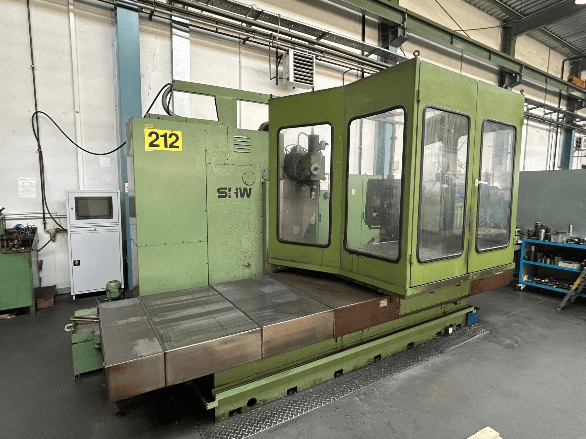SHW UF-5 Vertikal-Bearbeitungszentrum in grün, Frontansicht mit Bedienfeld, Glasgehäuse und Metall-Arbeitstisch.