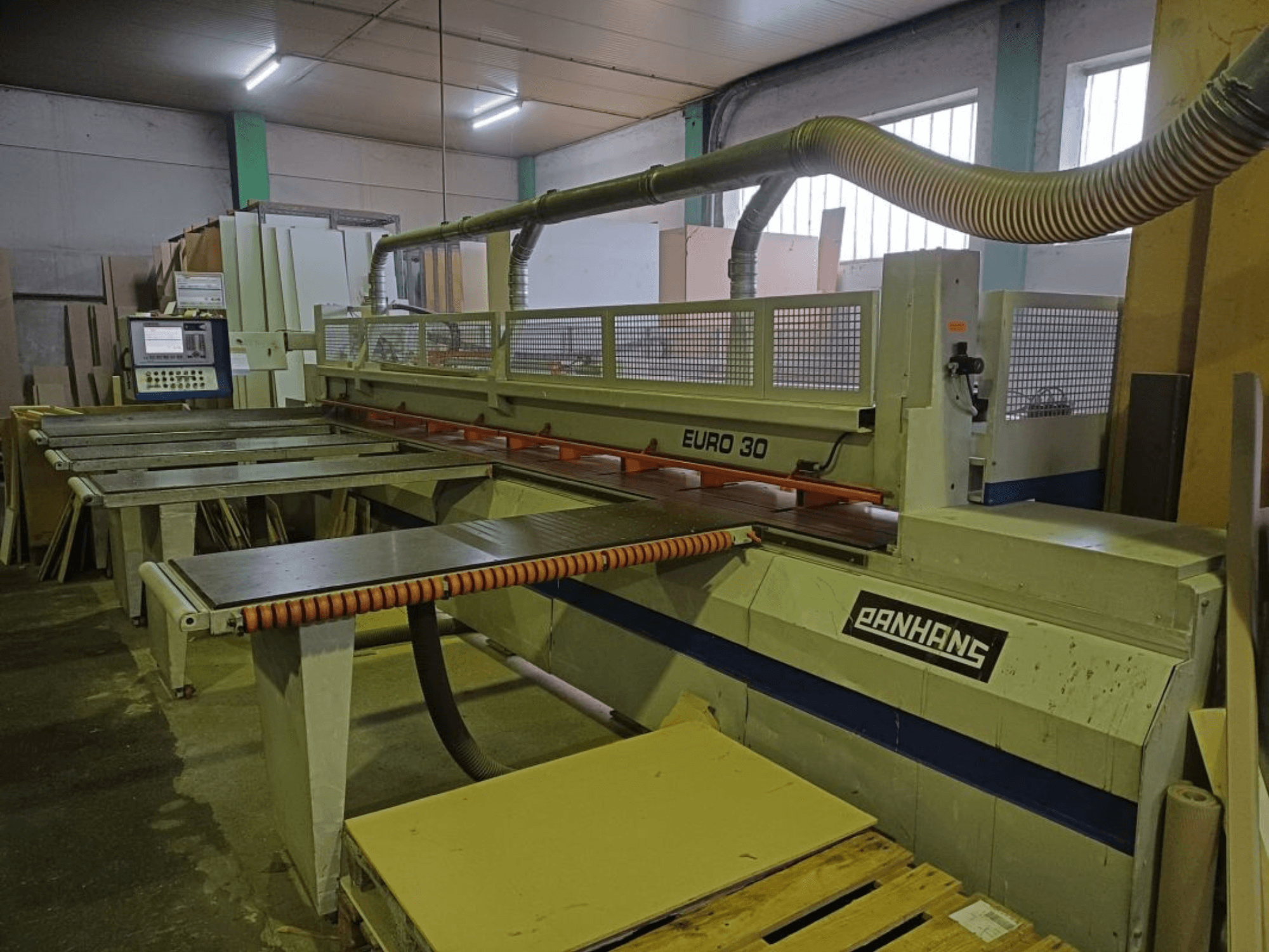 Vorderansicht der PANHANS EURO 30 Plattensäge mit Bedienpult, Schneidtisch und Absaugschlauch in einer Werkstattumgebung.