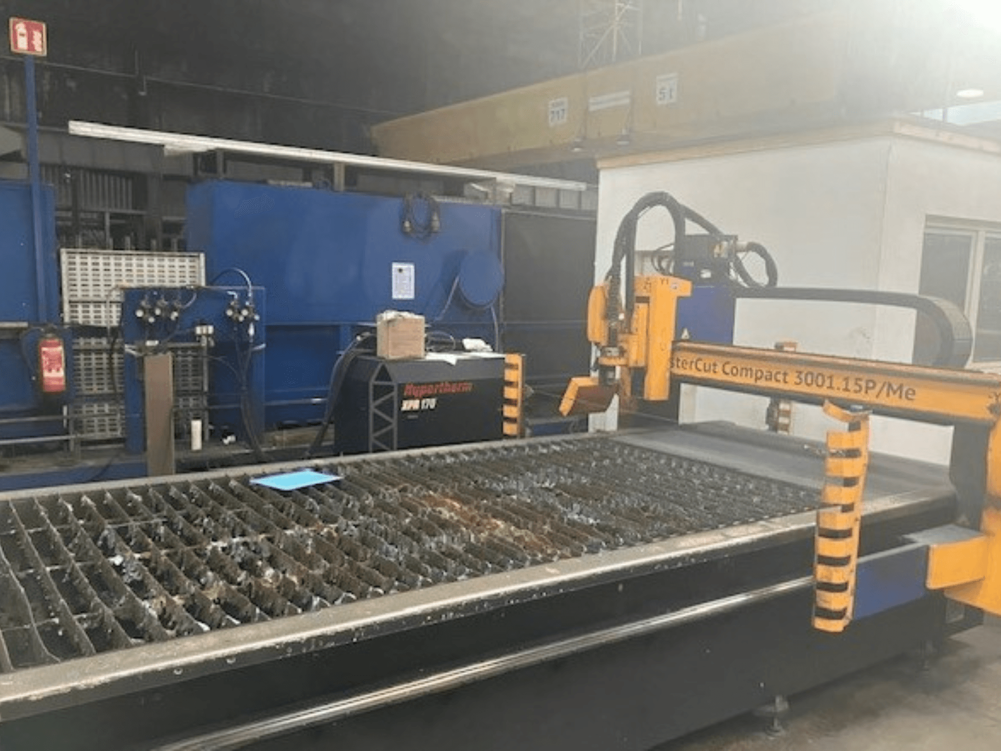 Hypertherm MasterCut Compact 3001.15P/Me Plasmaschneidanlage in der Seitenansicht, mit Schneidtisch und Bedienfeld.