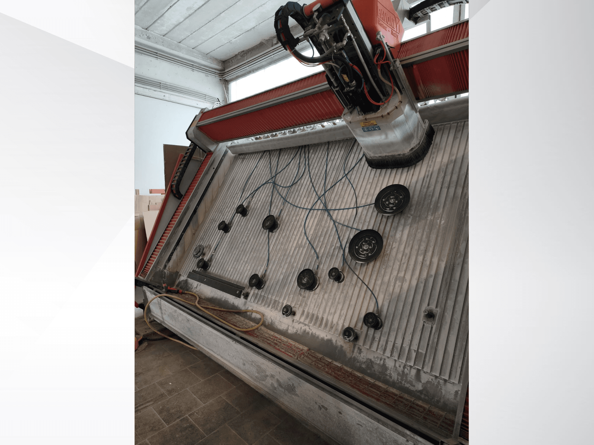 Vertikales Bearbeitungszentrum PAVONI V2400 „Open Top“, aus einem Winkel betrachtet, der den Arbeitsbereich und die mechanischen Komponenten zeigt.