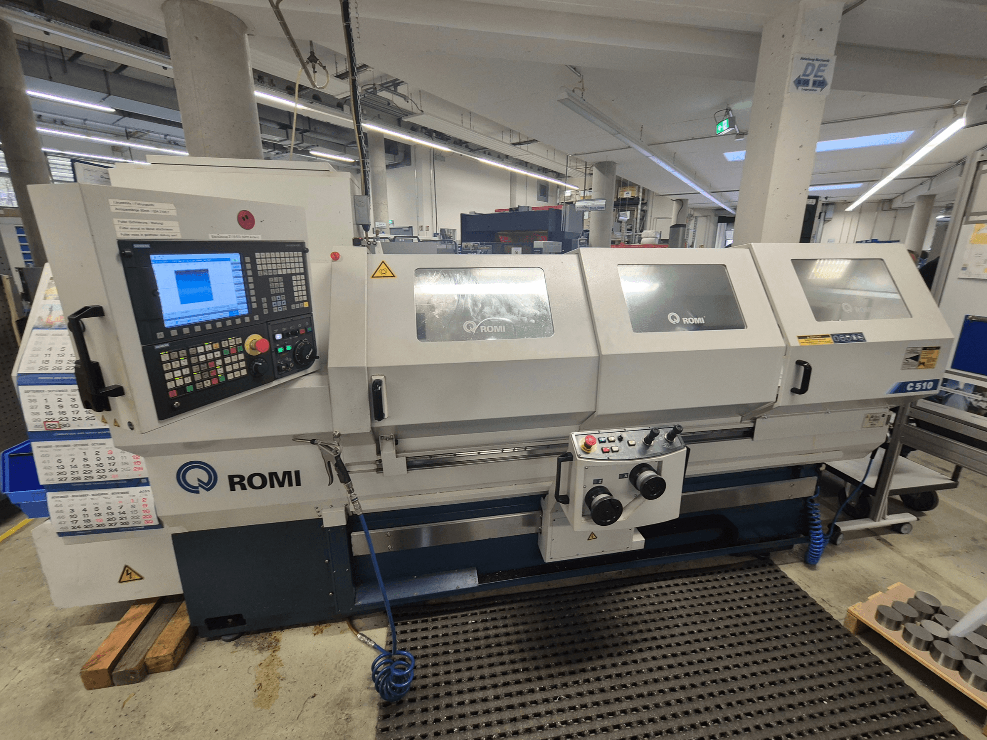 Romi C510 Drehmaschine von vorne gesehen, mit digitalem Bedienfeld und drei Schutzabdeckungen. Inklusive Sicherheitswarnschilder.