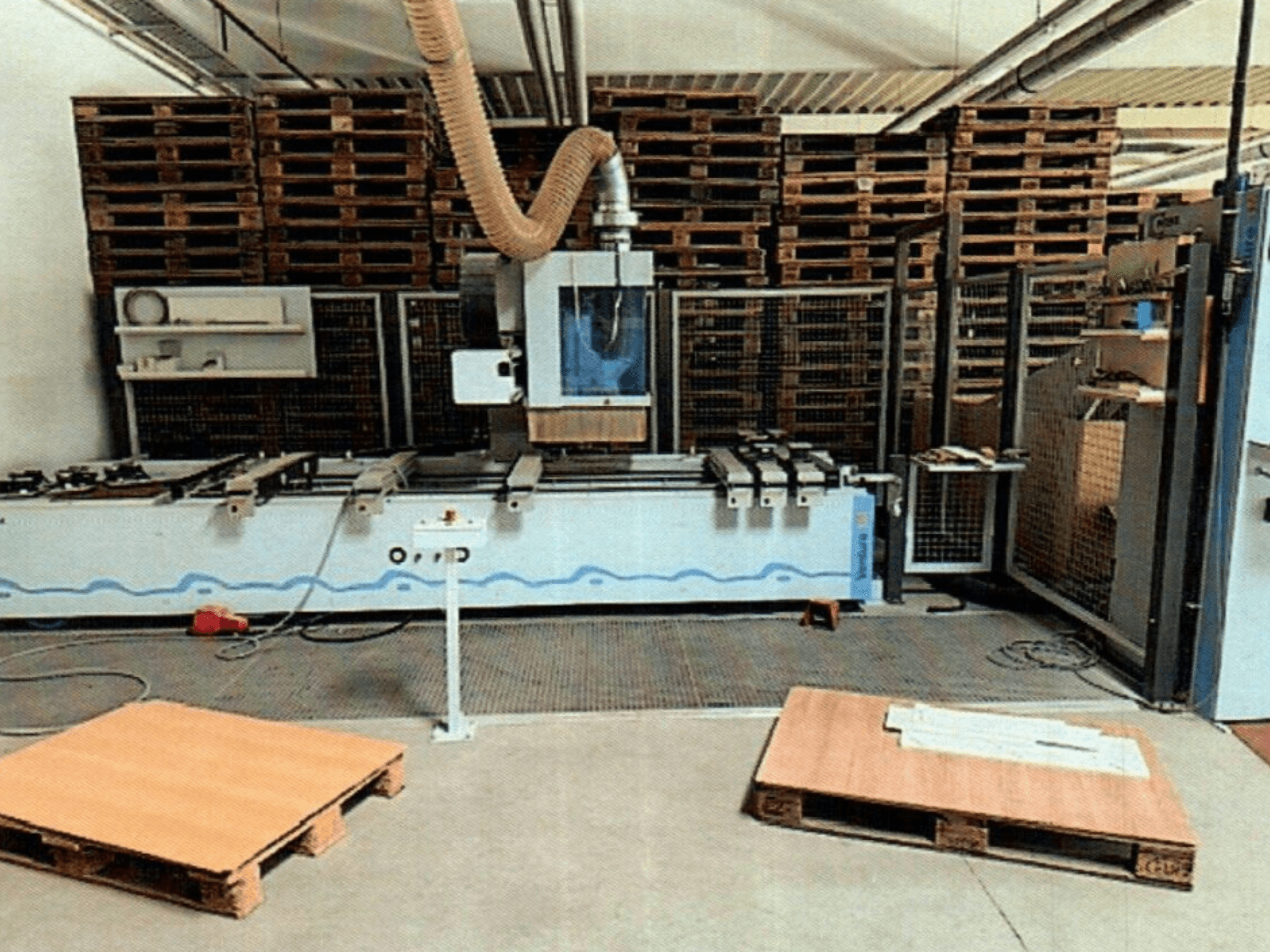 CNC-Holzbearbeitungszentrum Weeke Venture 1M in einer Werkstatt, Vorderansicht mit sichtbaren Holzpaletten und Industrieeinrichtung.