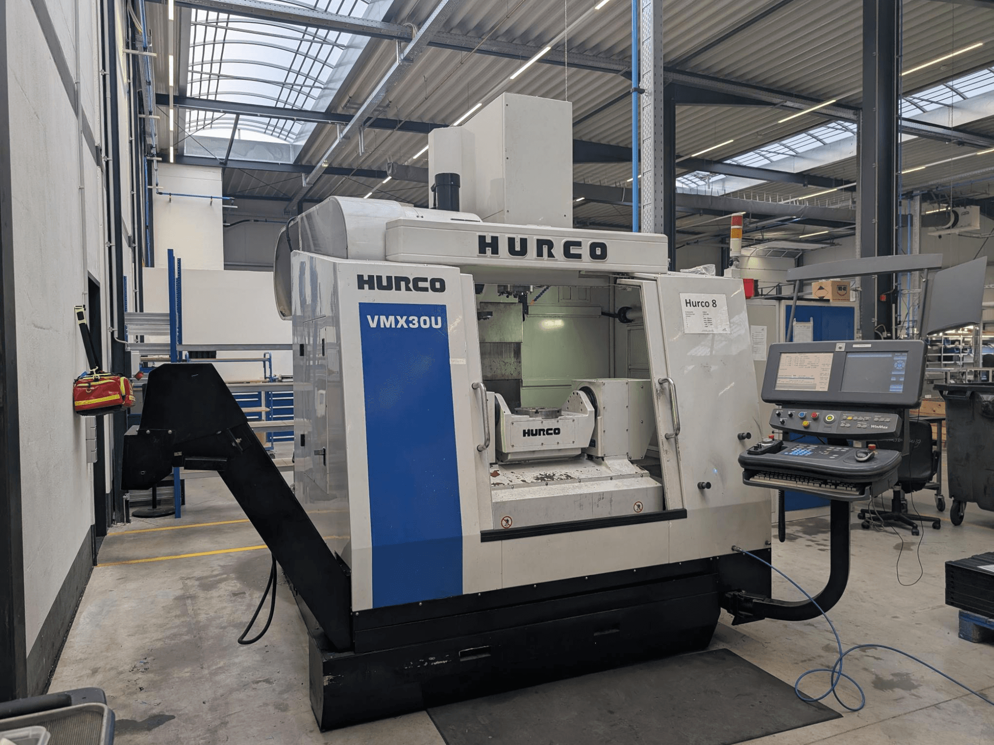 Hurco VMX30U CNC-Maschine in einer Werkstatt, Vorderansicht, mit Bedienfeld mit Tasten und Datenanzeige.