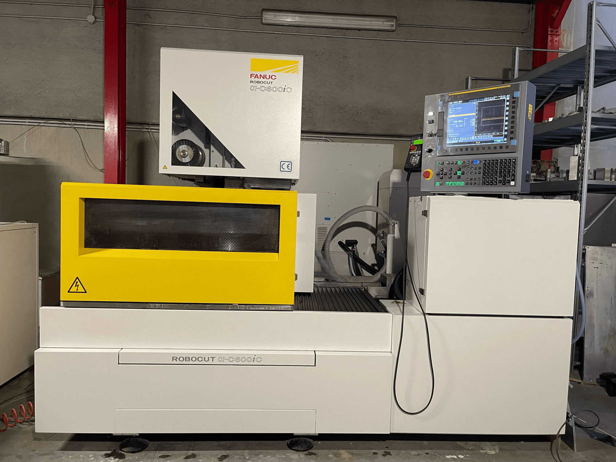 FANUC Robocut α-C600iC, Seitenansicht der CNC-Maschine mit gelber Sicherheitsabdeckung und Bedienfeld, die die Fähigkeit zum Präzisionsschneiden zeigt.