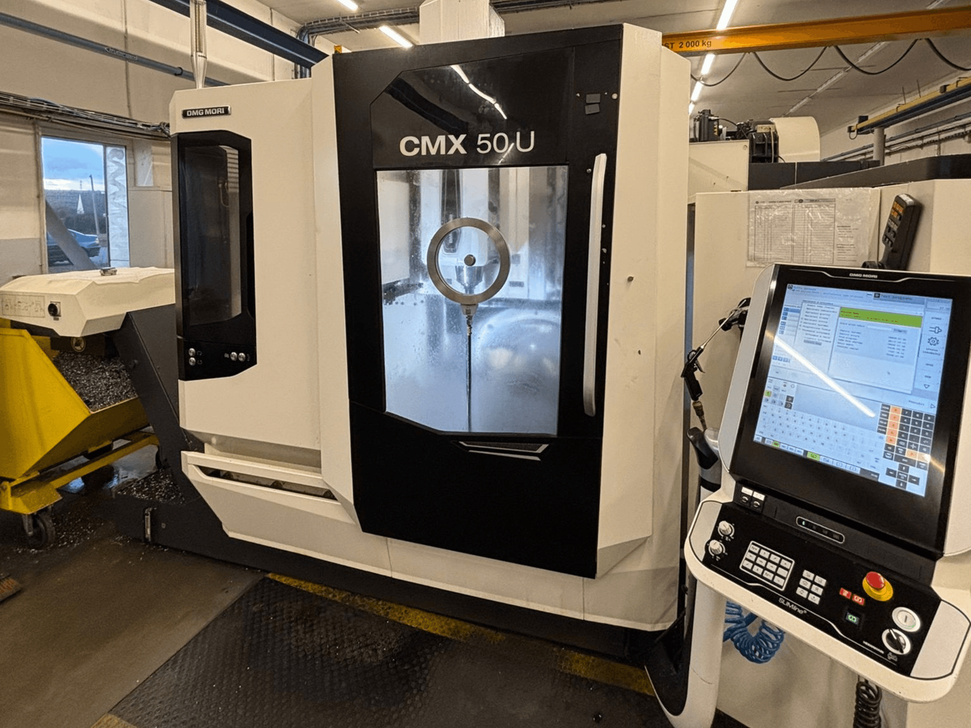 DMG MORI CMX 50 U Vertikal-Bearbeitungszentrum, Frontansicht mit Bedienfeld und Glasdisplay, Darstellung der internen Mechanik.