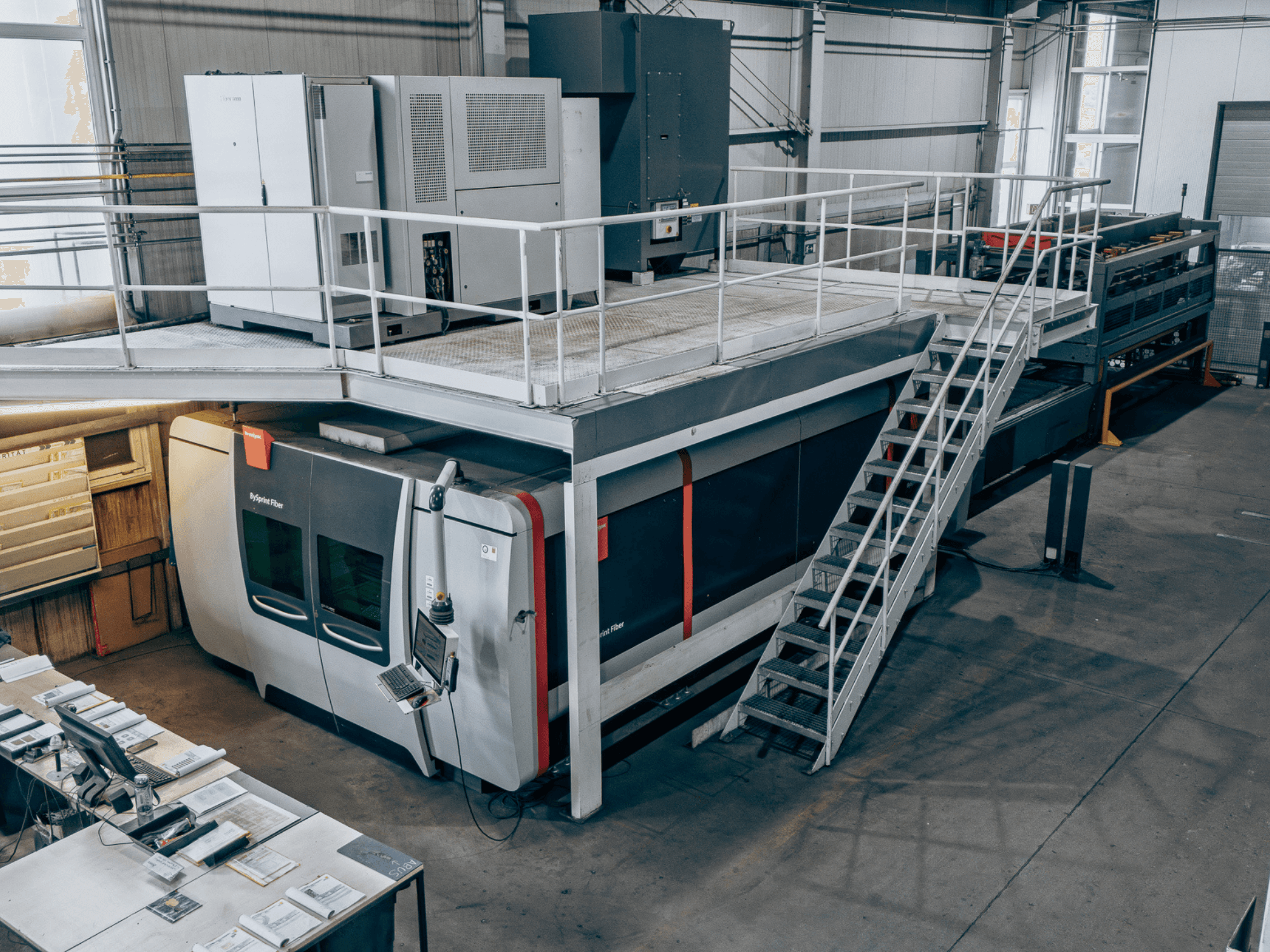 Faserlaserschneidemaschine „Bystronic BySprint Fiber 4020“ mit „ByTransExtended 4020“, von oben gesehen, mit Bedienfeld und Treppe.