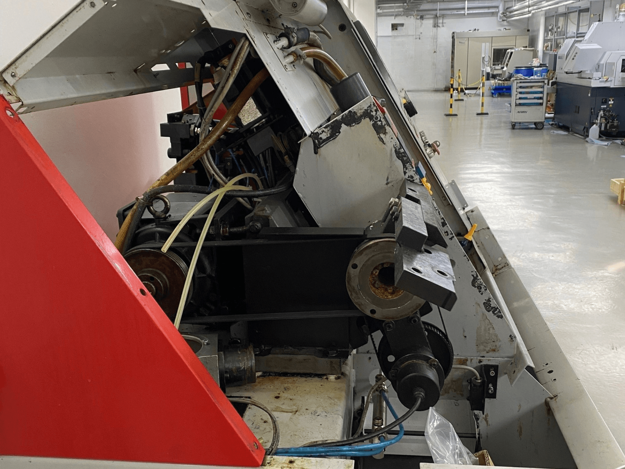 EMCO Emcoturn 325 Horizontaldrehmaschine, Seitenansicht mit Antriebskomponenten und Hydraulik in Industrieumgebung.