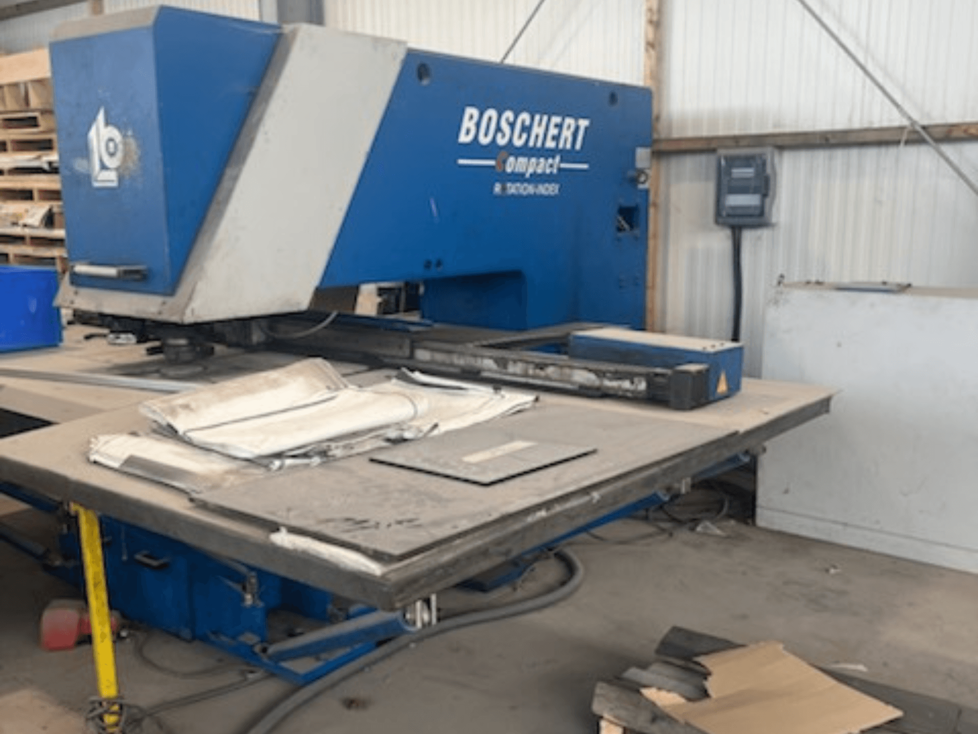 CNC-Stanzmaschine BOSCHERT COMPACT 1000 in einer Werkstatt, Frontansicht mit Blechen auf dem Tisch.