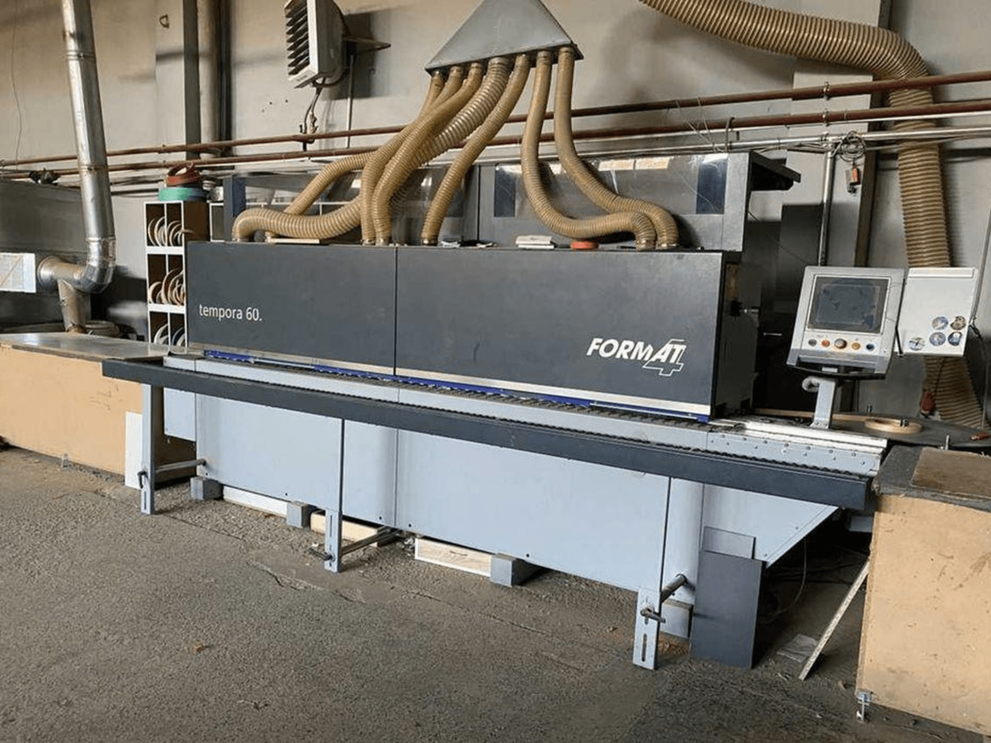 FORMAT4 Tempora 60 Kantenanleimmaschine in der Seitenansicht, mit mehreren Schläuchen und einem Bedienfeld mit Tasten und Bildschirm.