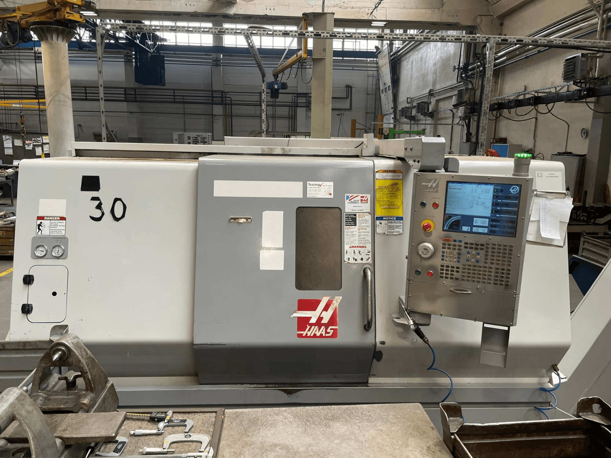 Frontansicht der Horizontal-Drehmaschine Haas SL-30THE mit digitalem Bedienfeld, Gefahrenhinweisen und der Modellnummer 30.