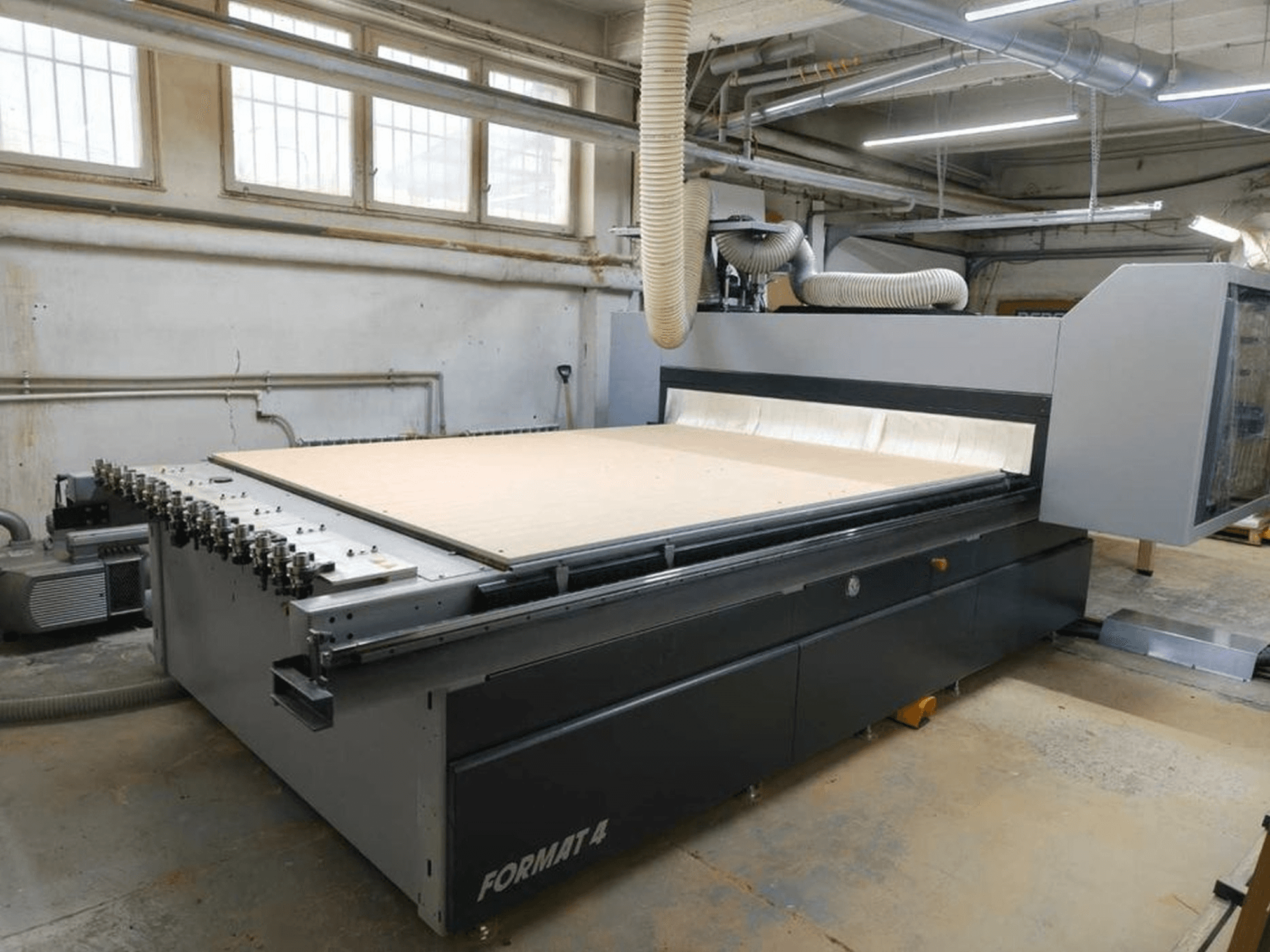 CNC Router FORMAT4 Profit H80 21.31 in der Werkstatt, Seitenansicht mit großer Schnittfläche und sichtbarem Schlauch für die Staubabsaugung.