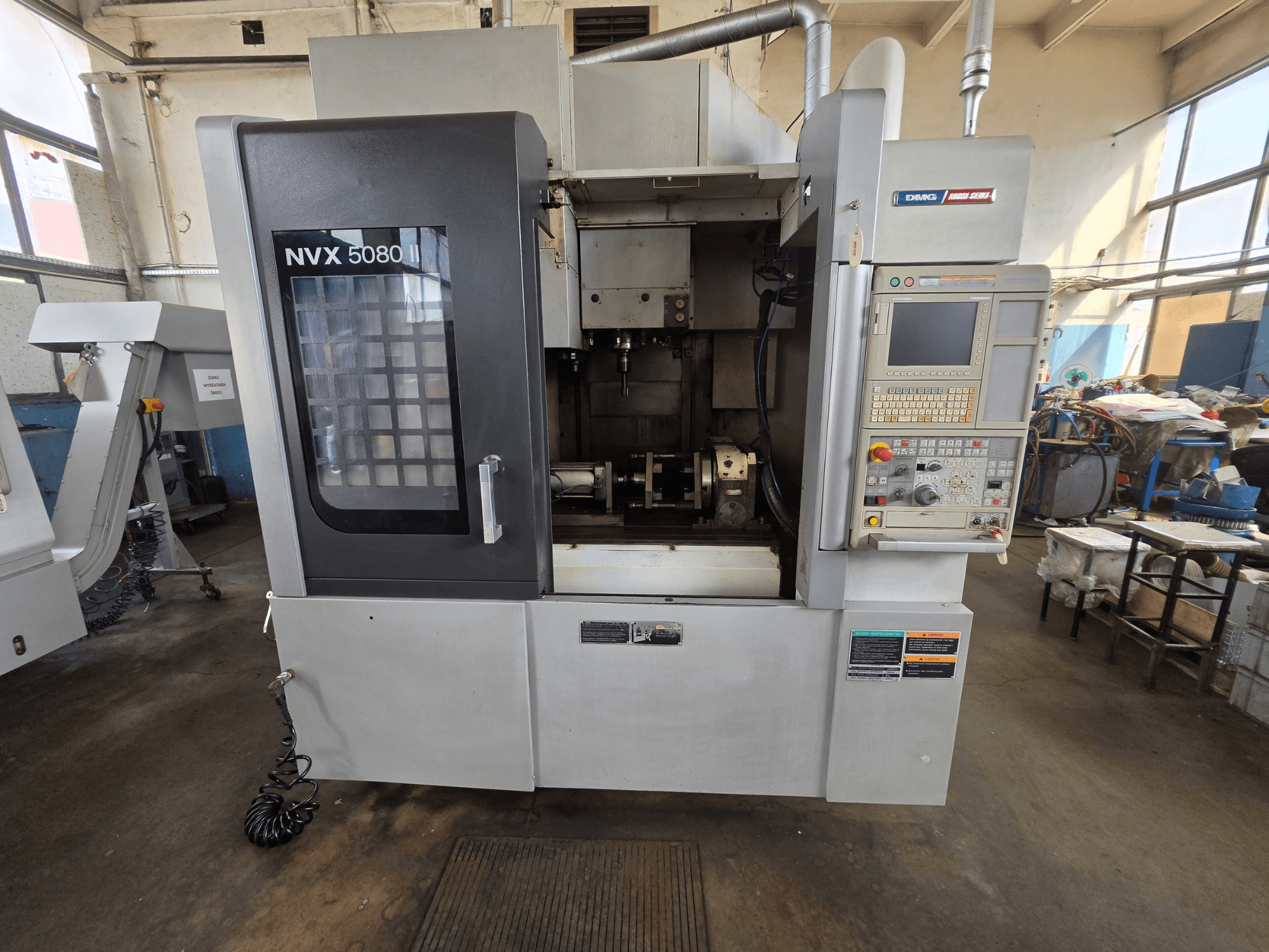Vorderansicht des vertikalen Bearbeitungszentrums DMG Mori Seiki NVX 5080 II/40 mit Bedienfeld und Sichtfenster, das den Bearbeitungsbereich zeigt.