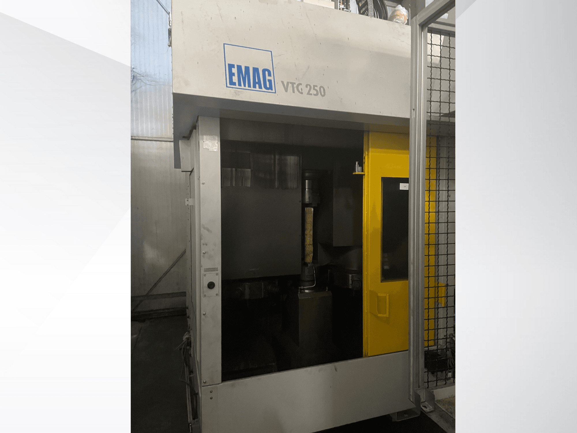 Vertikales Bearbeitungszentrum EMAG VTC 250 in der Vorderansicht, mit gelber Tür und sichtbarem Schneidwerkzeug in der Kammer.