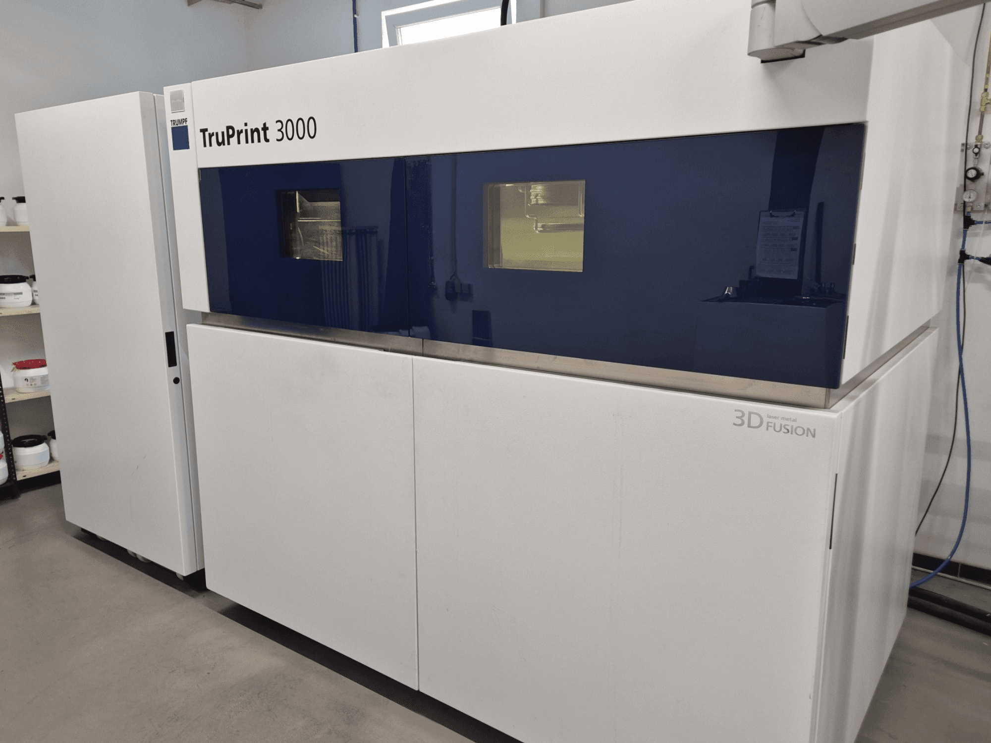 TruPrint 3000 Metall-3D-Drucker in der Frontansicht, mit blauem Paneeldesign und Laserfusionstechnologie.