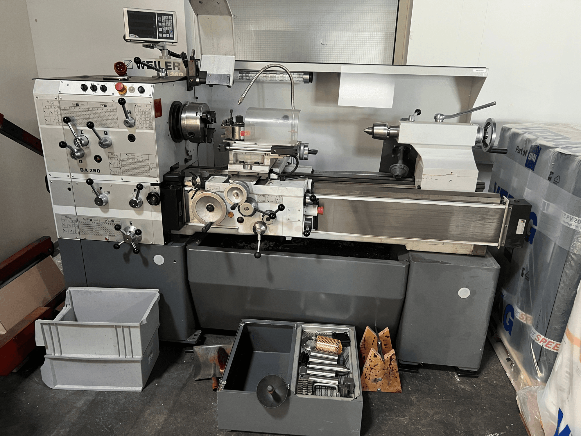 Weiler DA 260 X 1000 Horizontal-Drehmaschine in Vorderansicht, mit Bedienfeld und Werkzeugen sowie Ablagefächern darunter.
