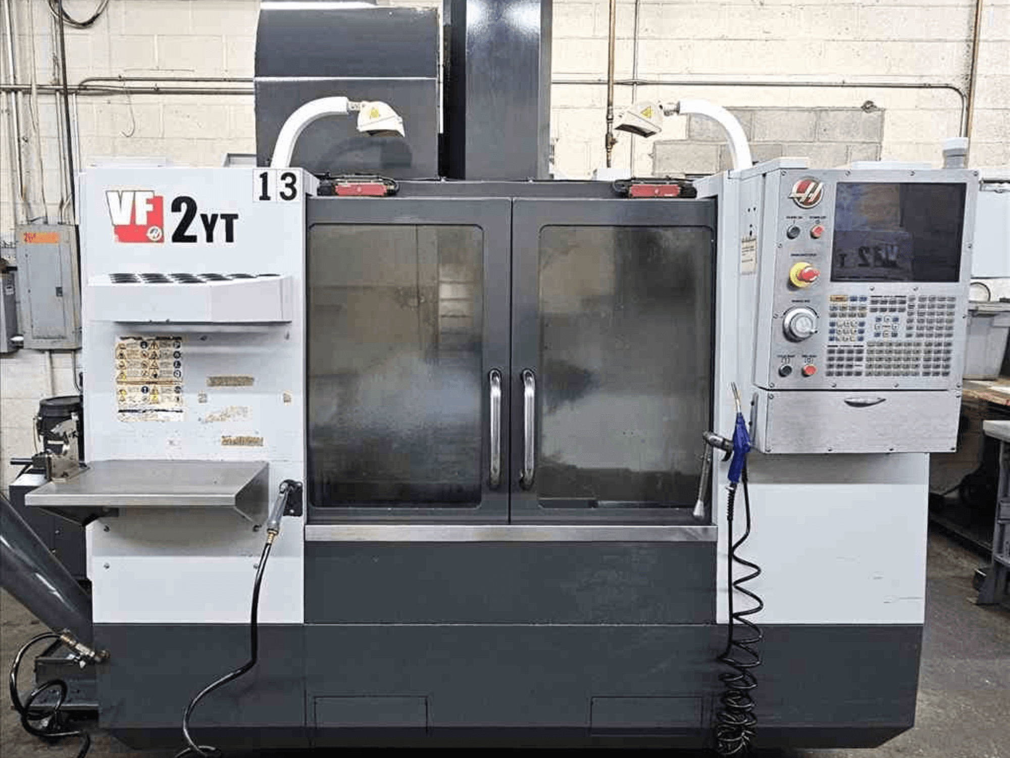 Frontansicht eines HAAS VF-2YT Vertikal-Bearbeitungszentrums mit Bedienfeld und Glastüren.