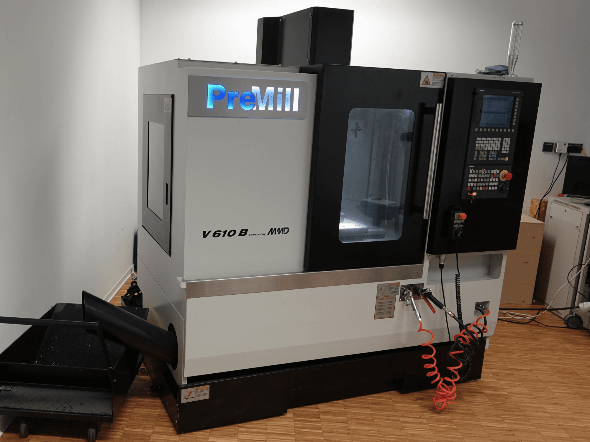 Vertikales Bearbeitungszentrum PreMill V 610 B, Vorderansicht, mit Bedienfeld, Kühlmittelsystem und angeschlossenen Luftschläuchen.