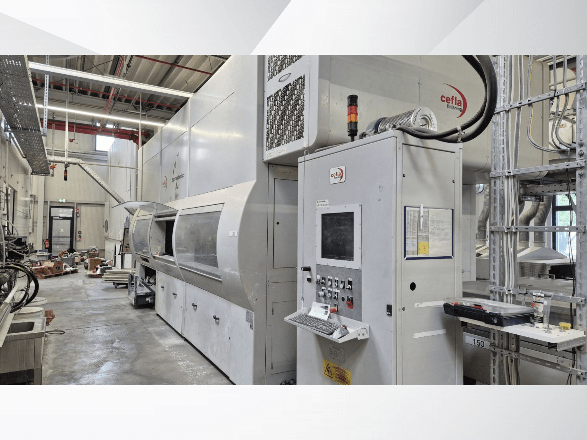 Cefla Spraybotic MD-Produktionslinie in einer Werkstatt, Vorderansicht mit Bedienfeld und Sprühkammer mit transparenter Abdeckung.