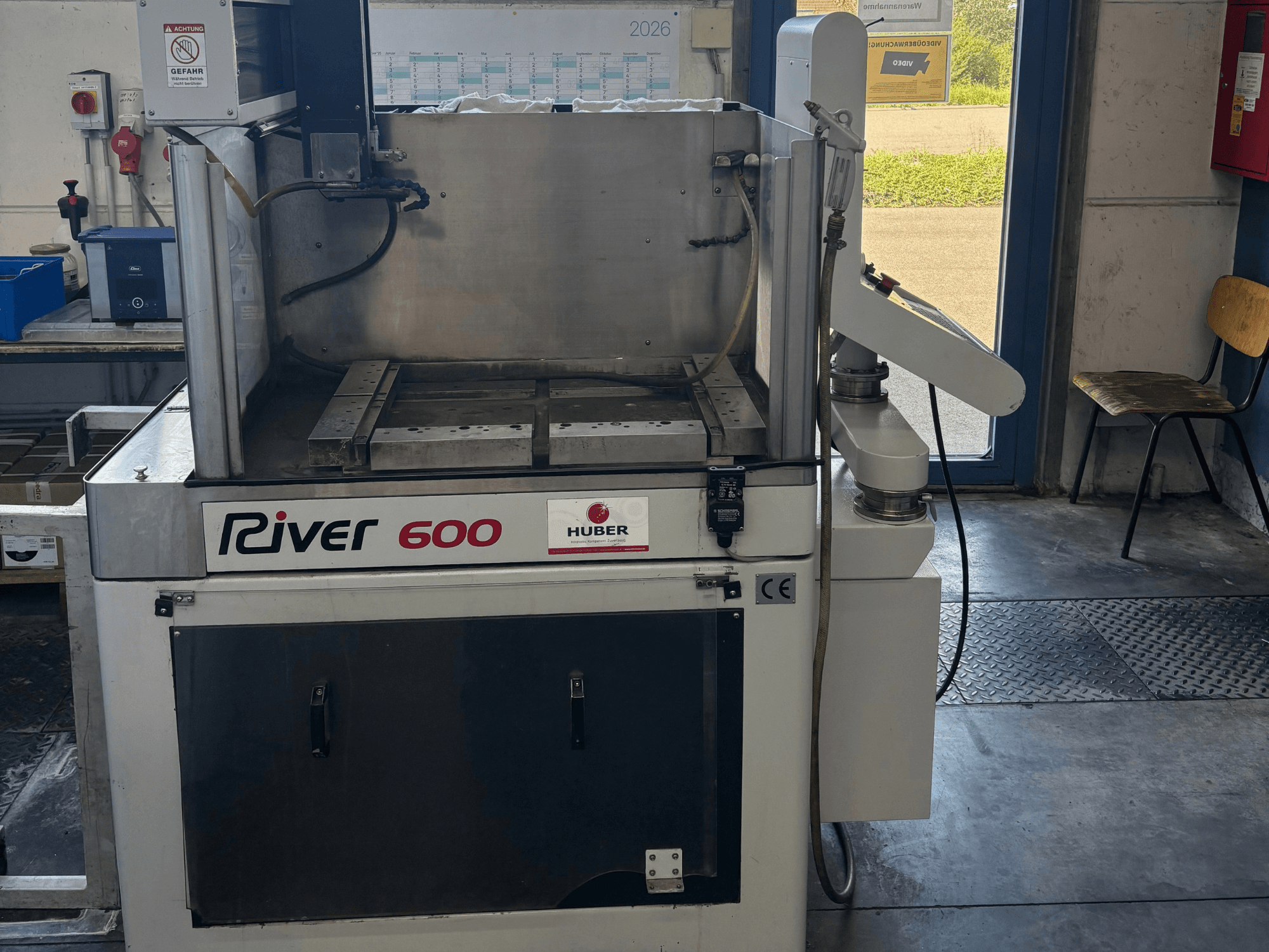 HUBER River 600 CNC-Senkerodiermaschine, Vorderansicht, mit teilweise geöffneter Arbeitskammer und Bedienfeld.