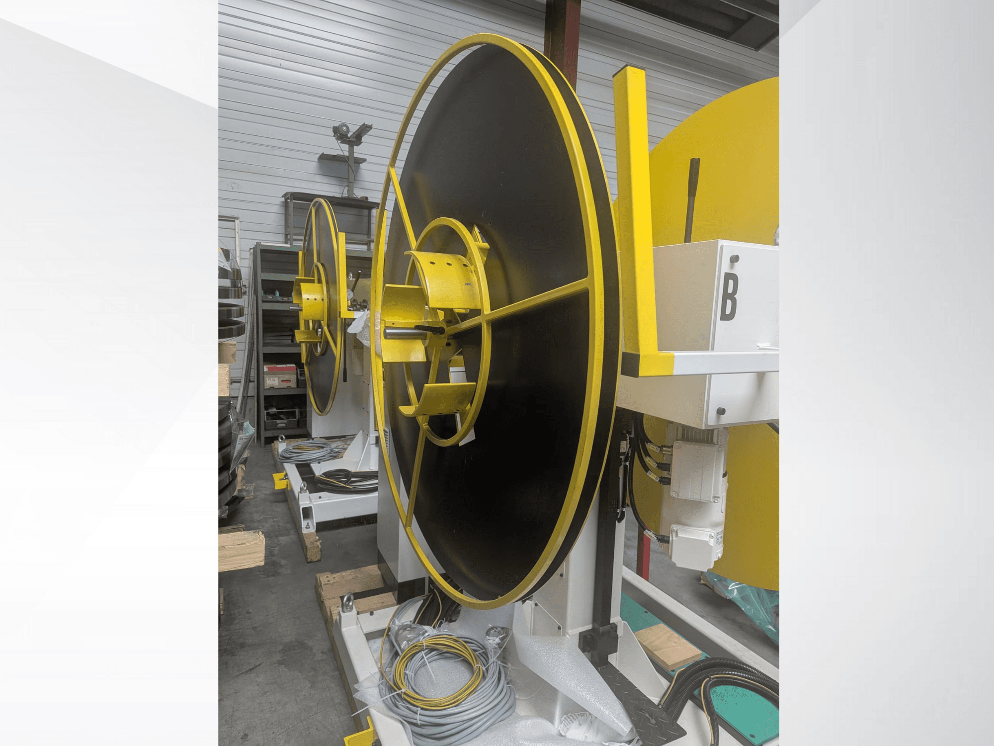 Große Industriespule, Modell XYZ, mit schwarzer Oberfläche und gelben Akzenten, in der Seitenansicht, mit elektrischen Anschlüssen.