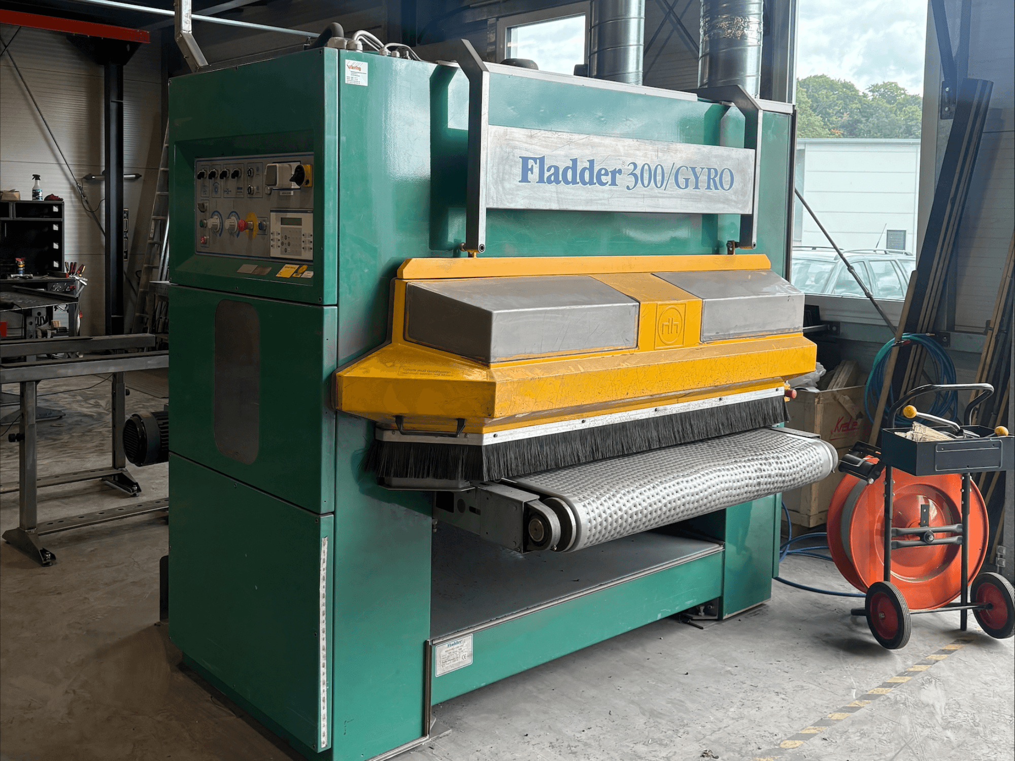 Fladder 300/GYRO Industrie-Schleifmaschine in grün und gelb, Vorderansicht, mit Bedienfeld und Schleiftrommel.