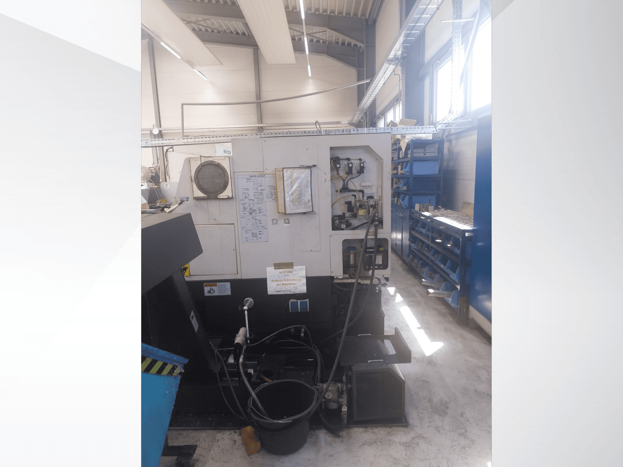 Mazak QUICK TURN NEXUS 200 MS, Seitenansicht mit Bedienfeld, Schläuchen und Werkzeugbereich in einer Werkstattumgebung.