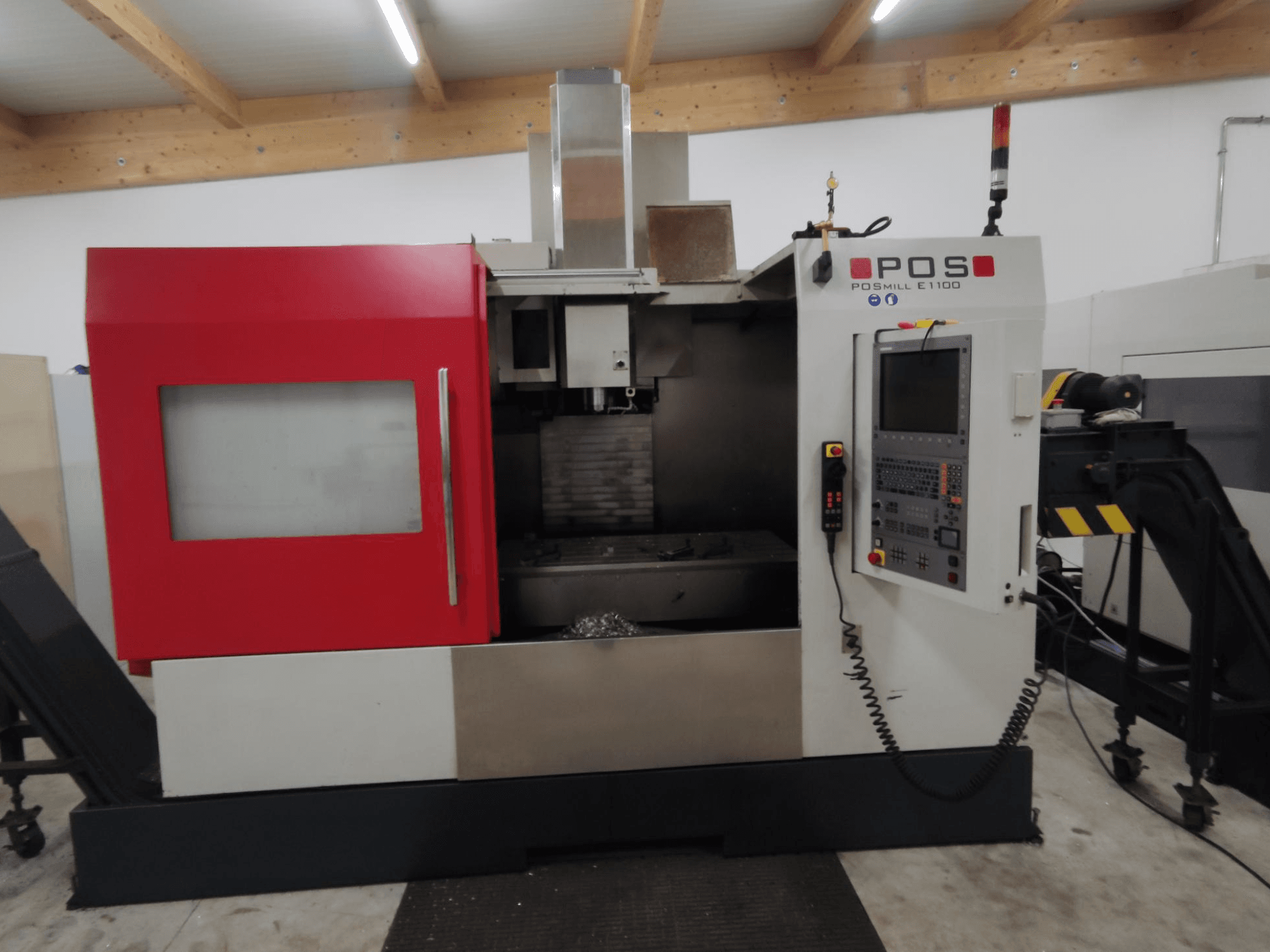 POS PSMILL E1100 CNC-Fräsmaschine, Vorderansicht, mit rotem und silbernem Gehäuse, Bedienfeld und Sicherheitsanzeigeleuchten.